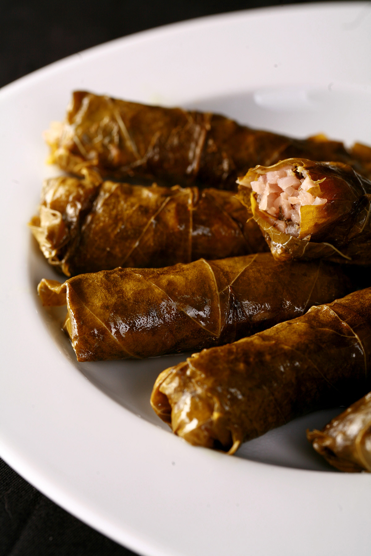A white plate with low carb, paleo stuffed grape leaves on it.