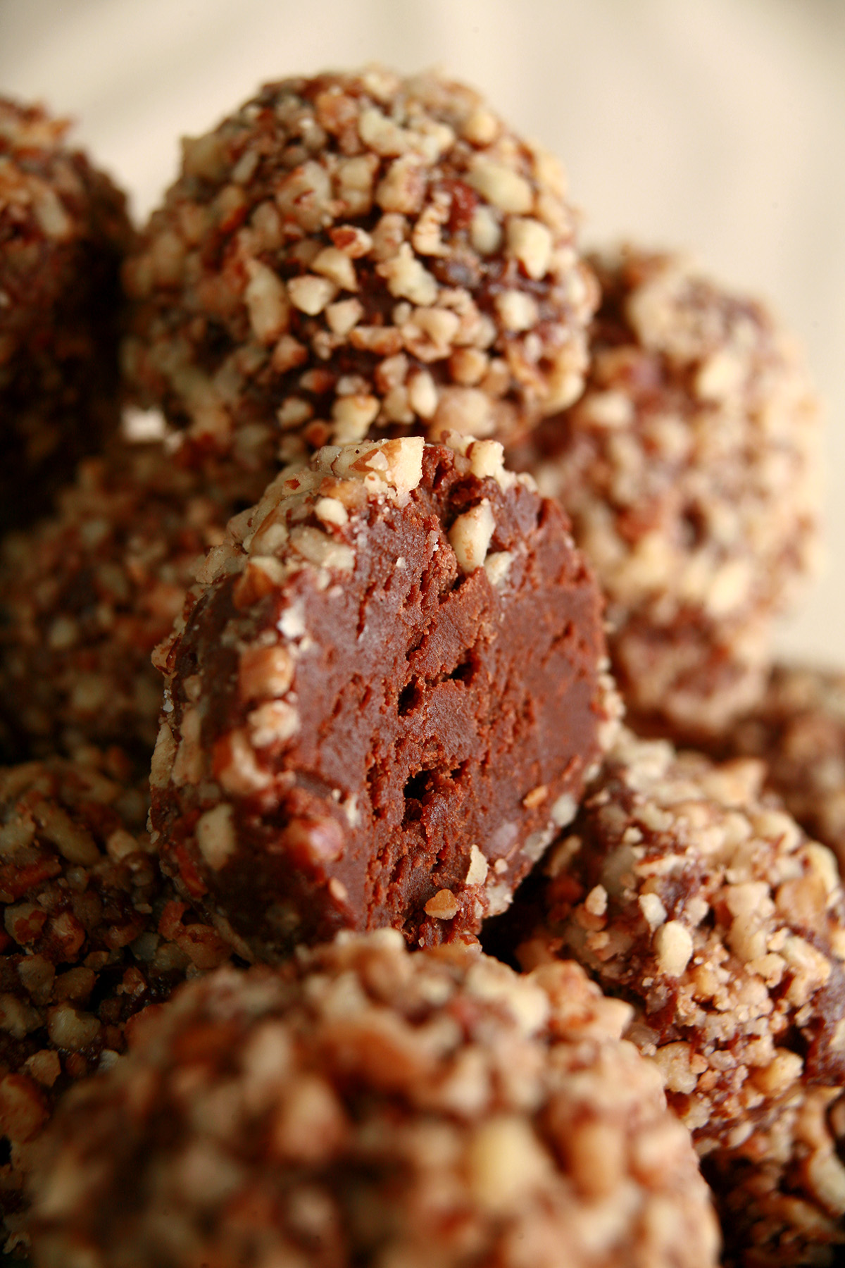 A red plate piled high with low carb bananas foster truffles. They are coated in crushed pecans.