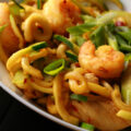 A white bowl with singapore mai fun style zoodles.