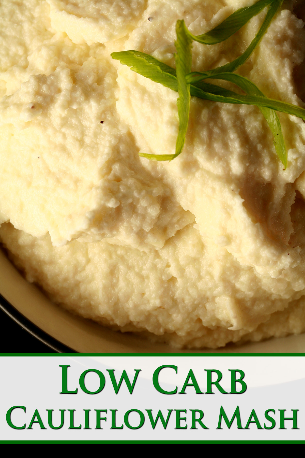 A close up view of a bowl of keto cauliflower mash, with sliced green onions on top. Green text overlay says low carb cauliflower mash.