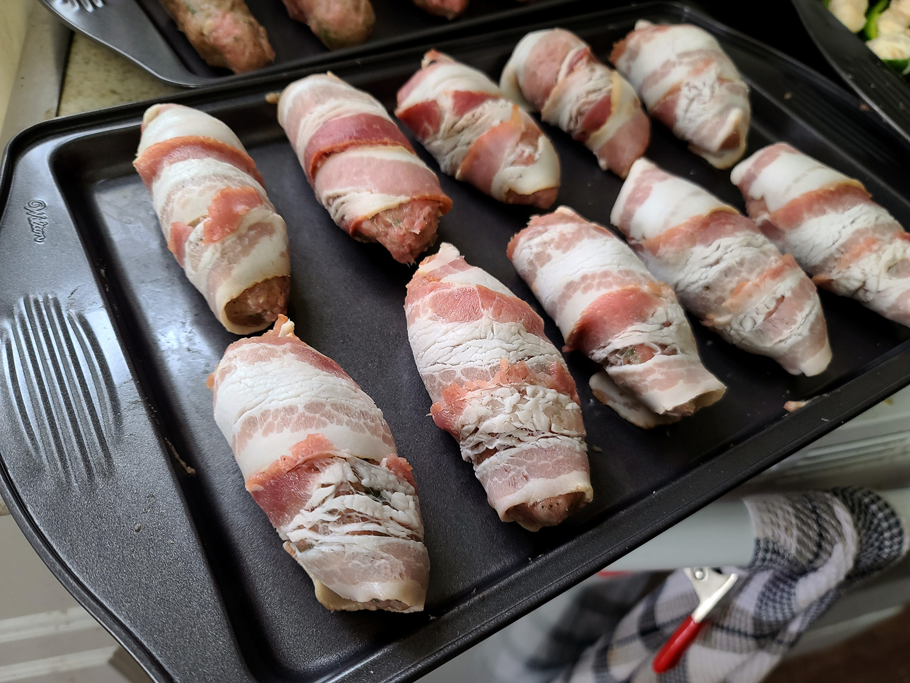 A close up view of a batch of uncooked chicken bacon ranch armadillo eggs.