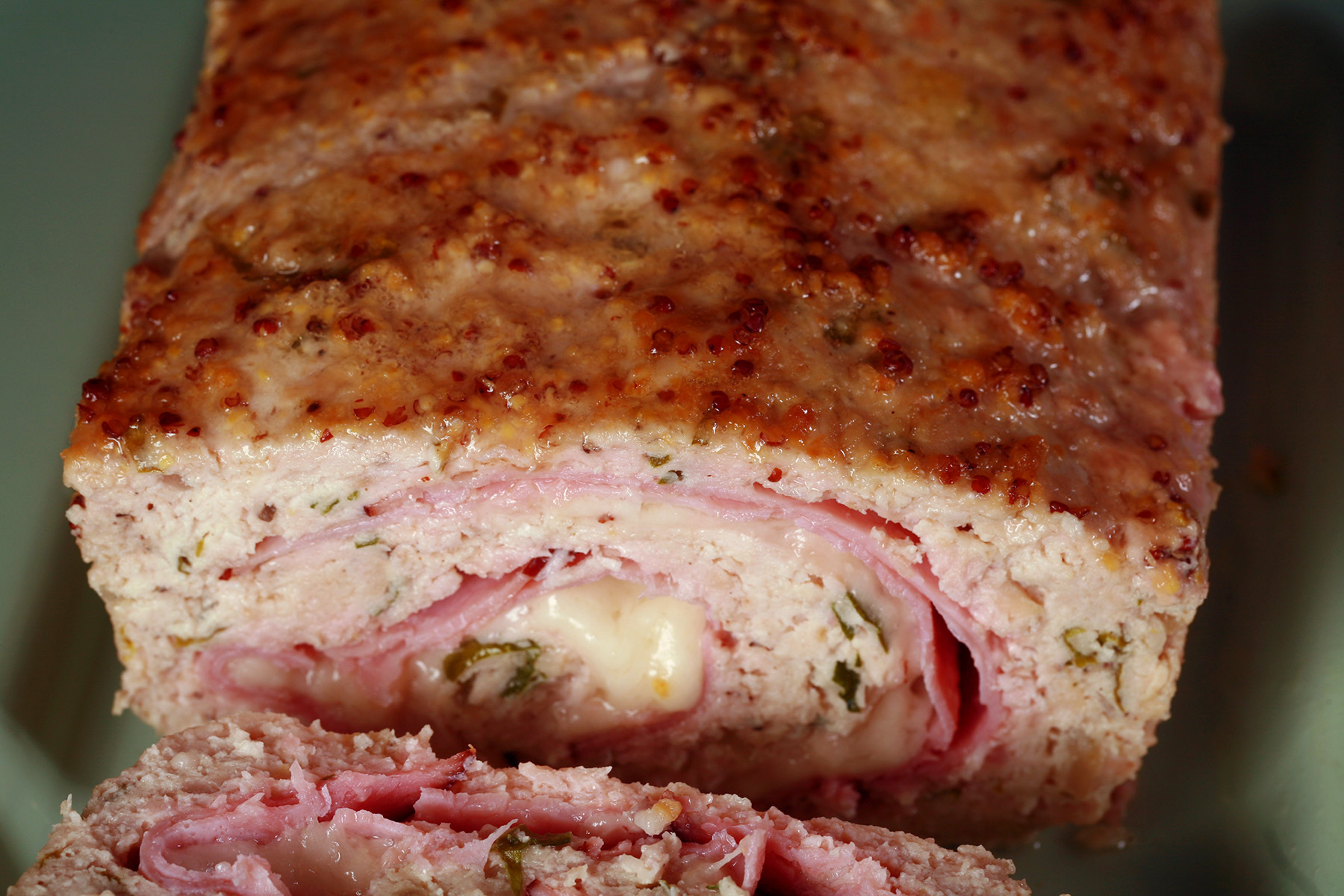 Low carb Chicken cordon bleu meatloaf, with a slice on a plate.