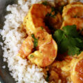 Keto shrimp curry, served over a bowl of cauliflower rice and garnished with cilantro.