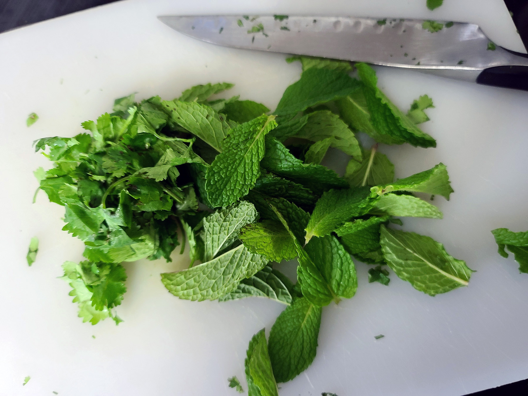 Cilantro and mint being chopped together.