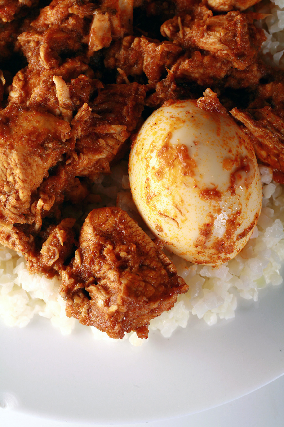Keto Doro Wat - a red chicken stew - on a serving of coconut cauliflower rice.