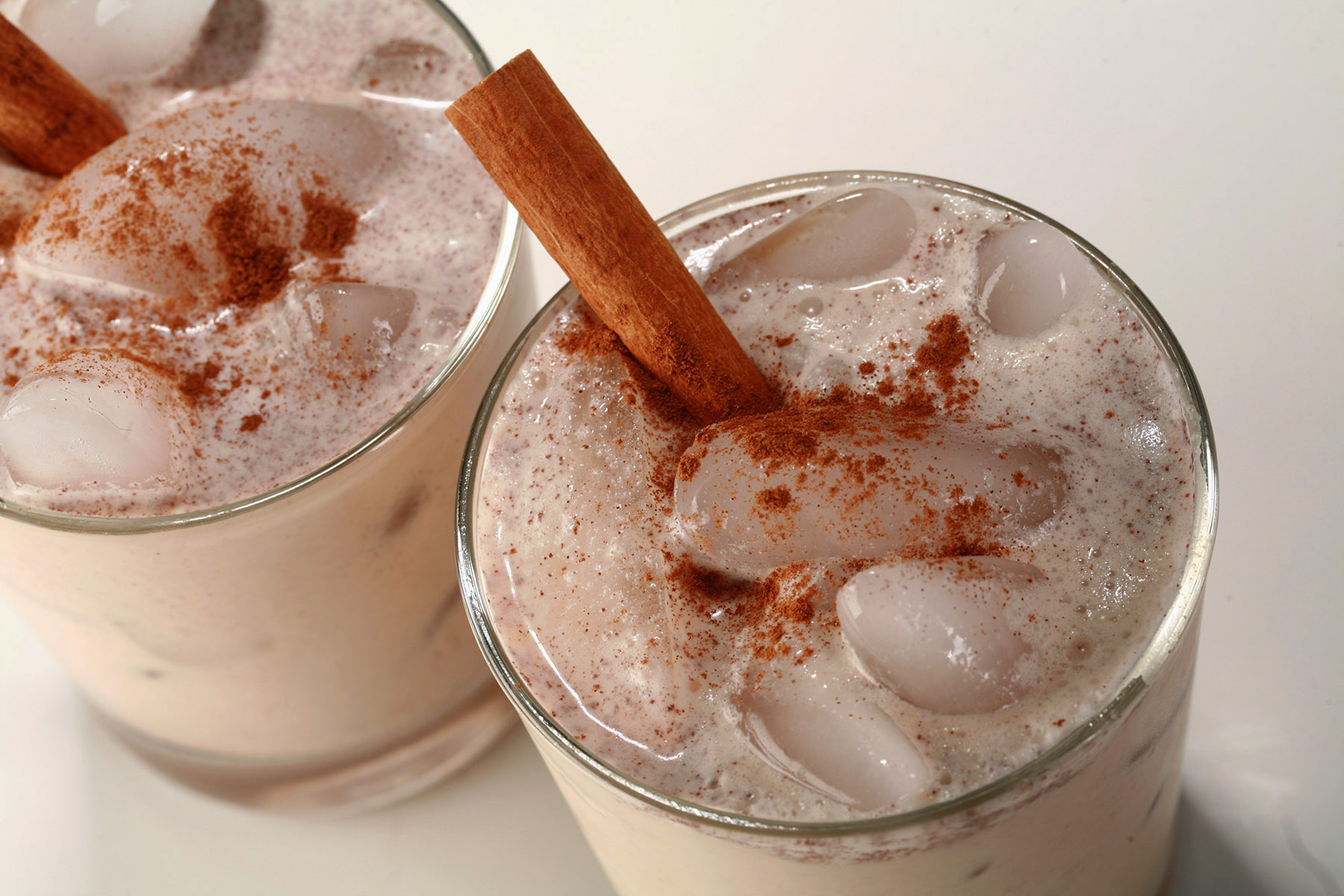 2 glasses of keto rumchata, garnished with a sinnamon stick and sprinkle of cinnamon.