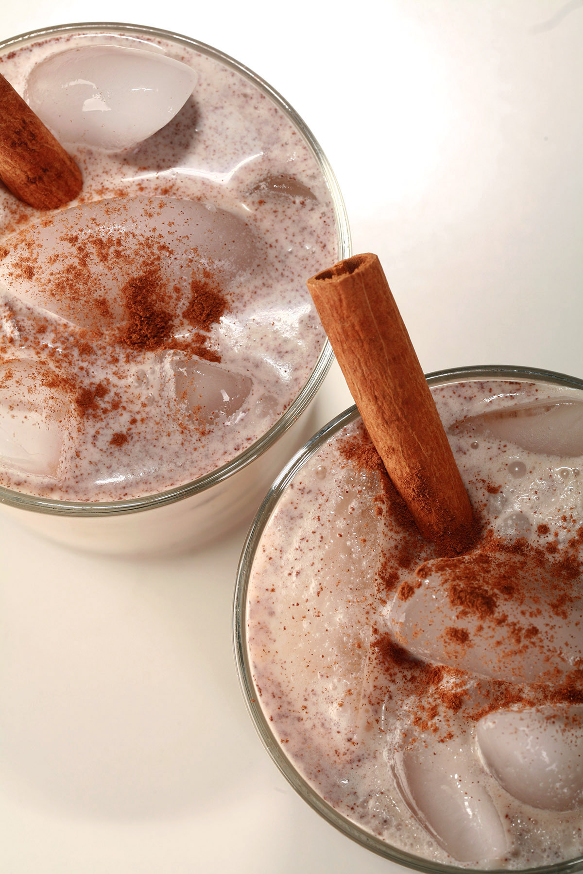 2 glasses of keto rumchata, garnished with a sinnamon stick and sprinkle of cinnamon.