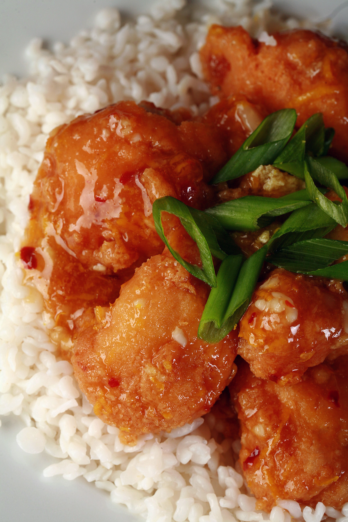 A plate of low carb spicy orange chicken served on konjac rice.