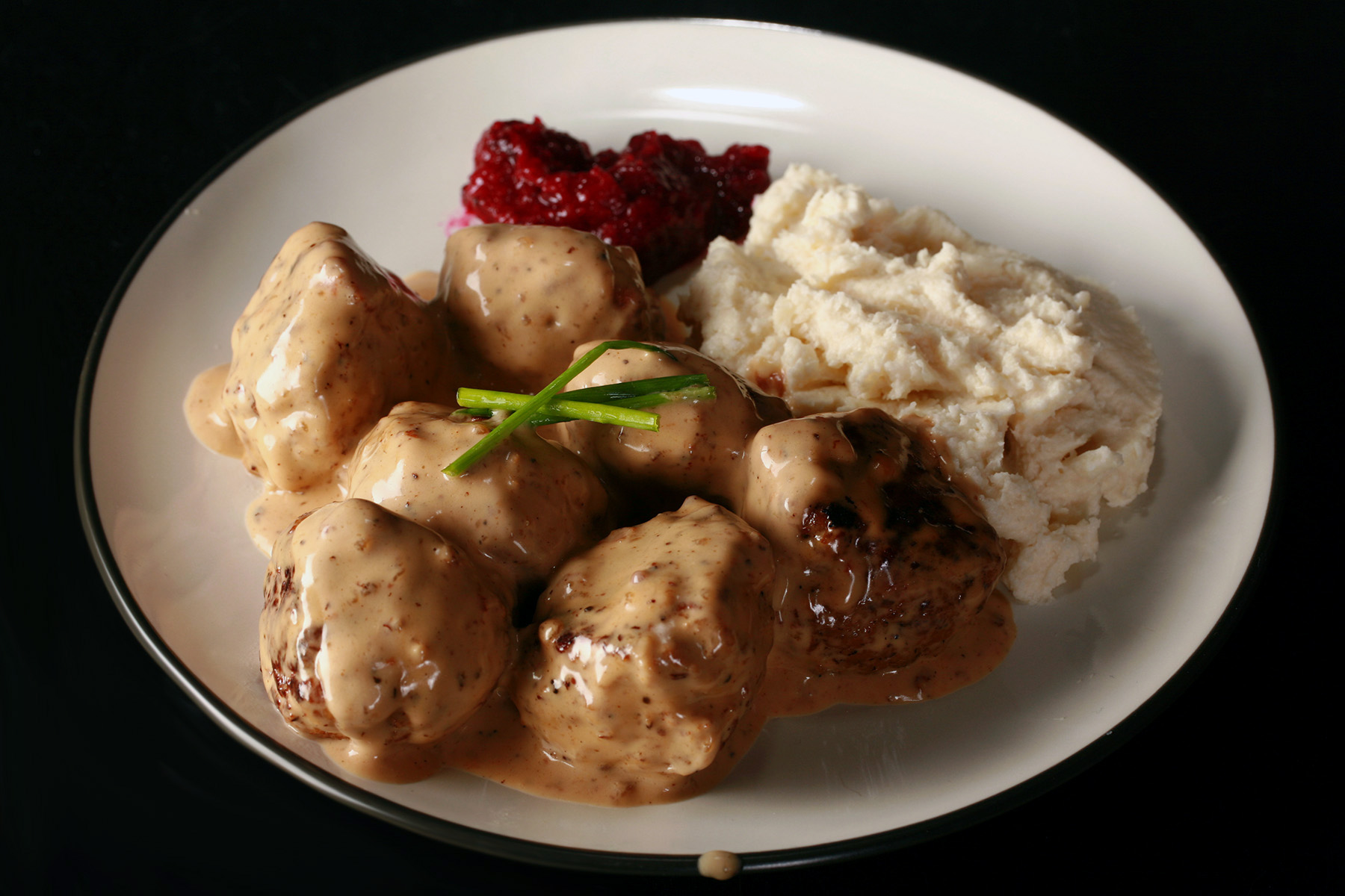 A plate of keto IKEA style Swedish meatballs with lingonberry sauce.