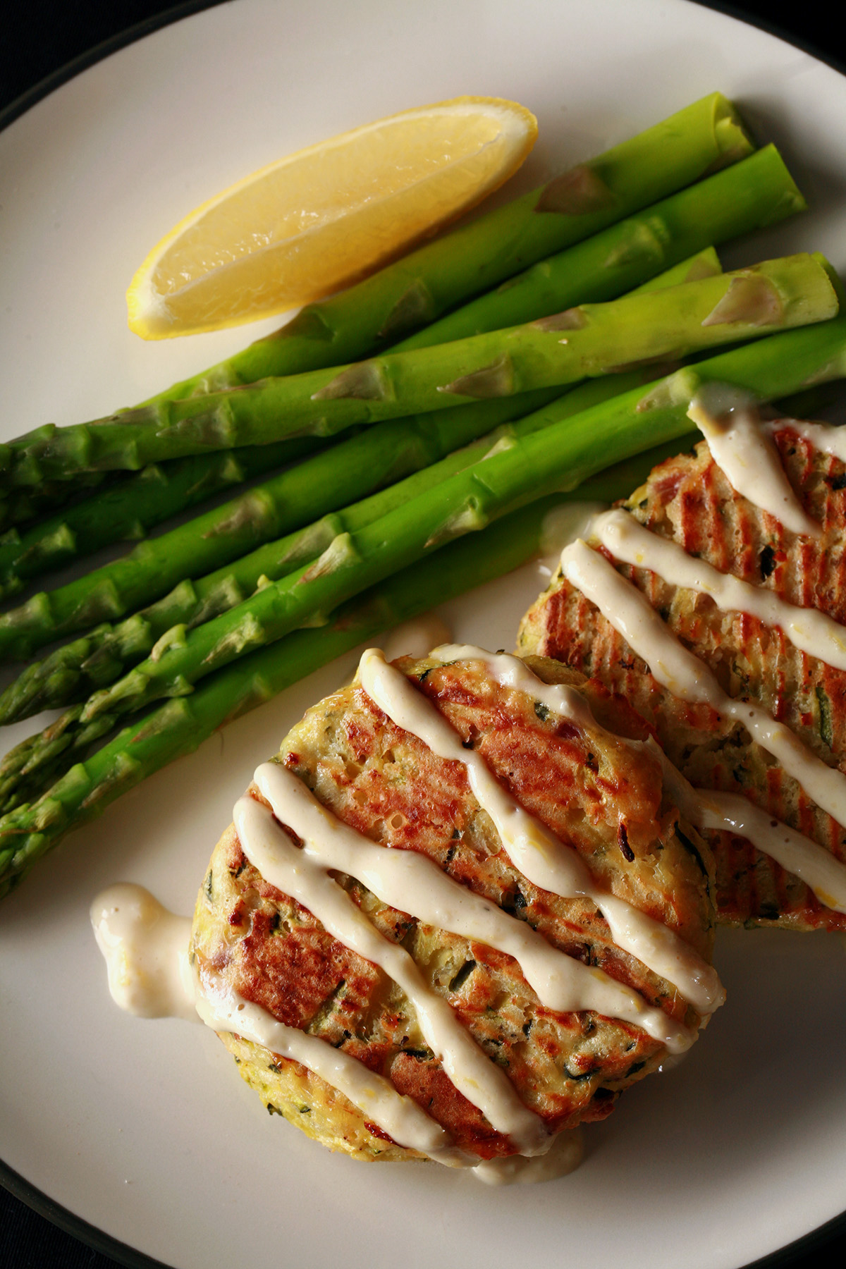 2 baked low carb zucchini patties, drizzled with lemon tahini sauce.