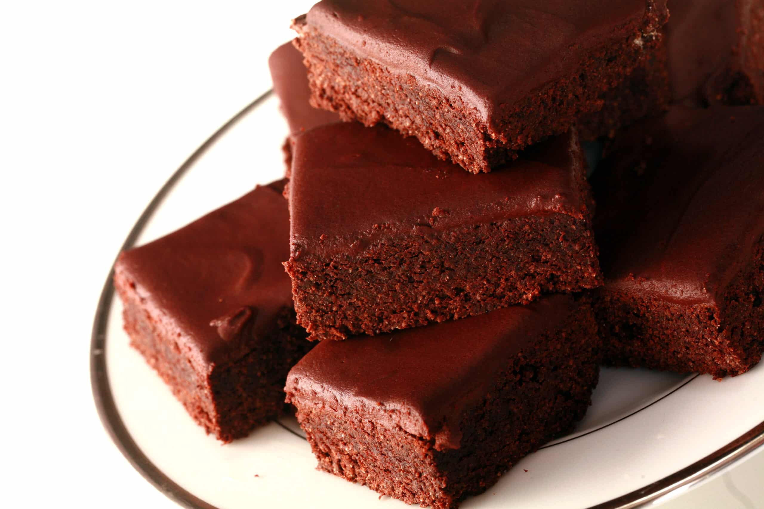 A stack of chocolate glazed low carb brownies.