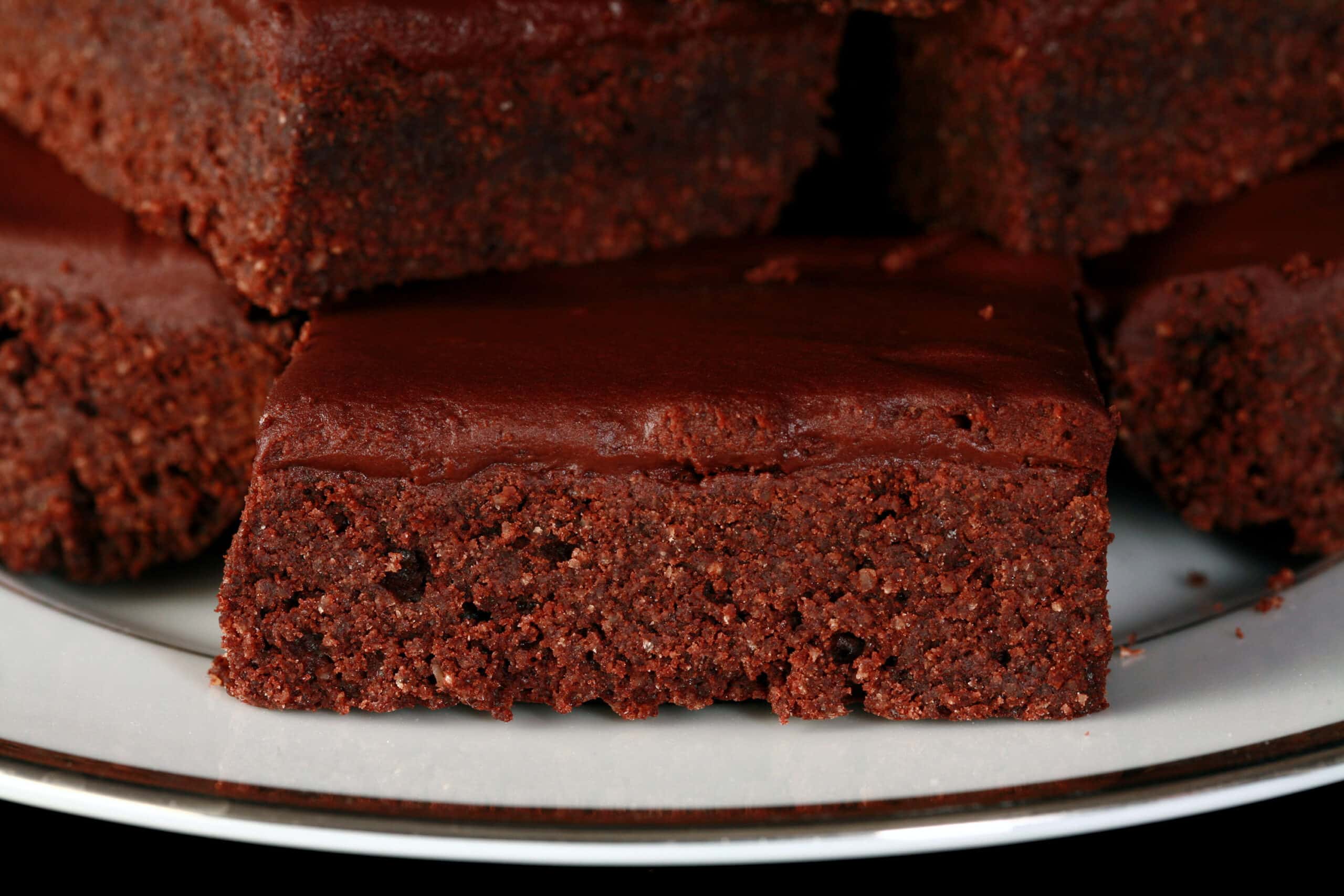A close up photo of a keto brownie with chocolate glaze.