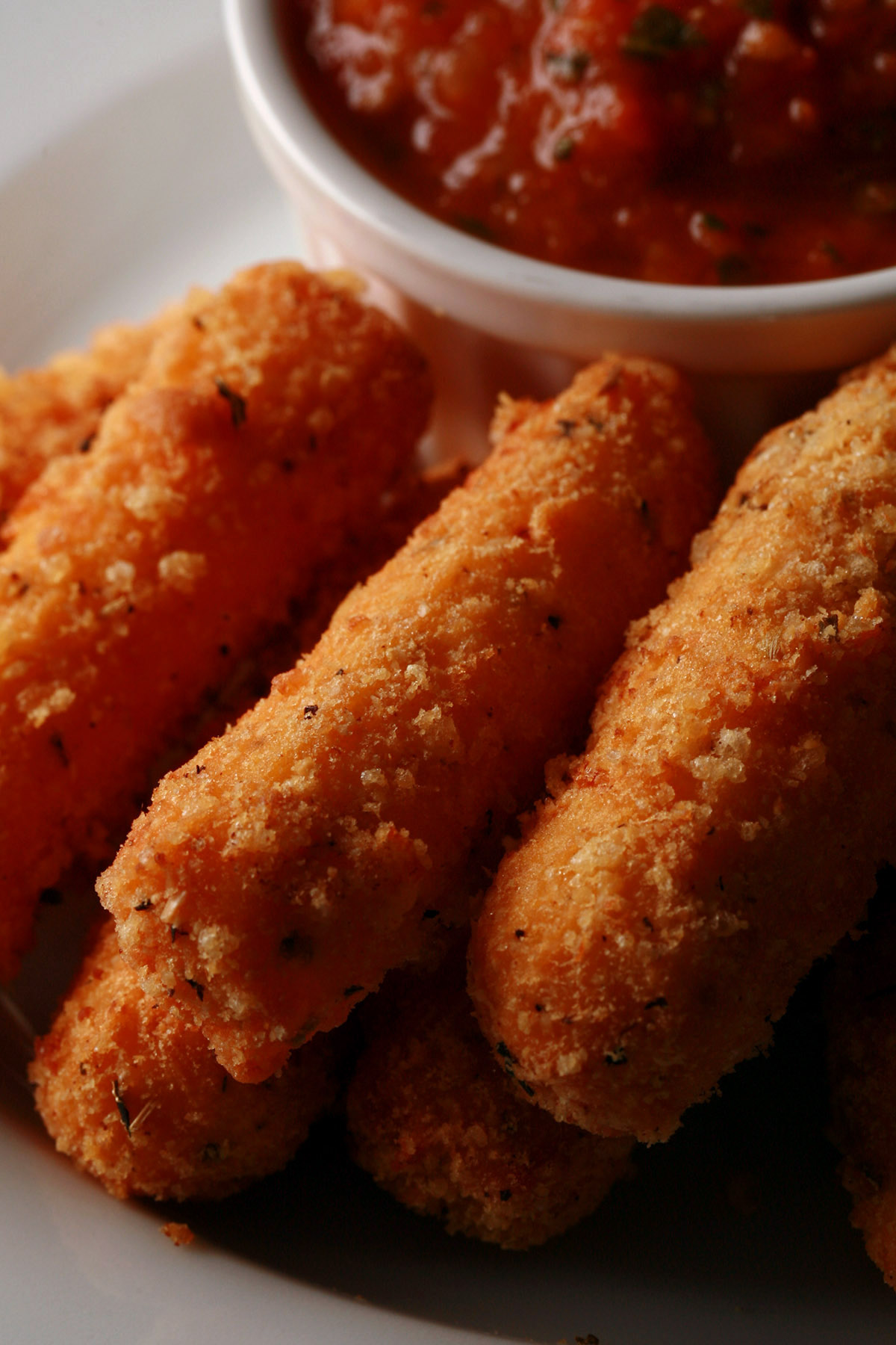 A plate of deep fried low carb mozzarella sticks, with keto marinara sauce.