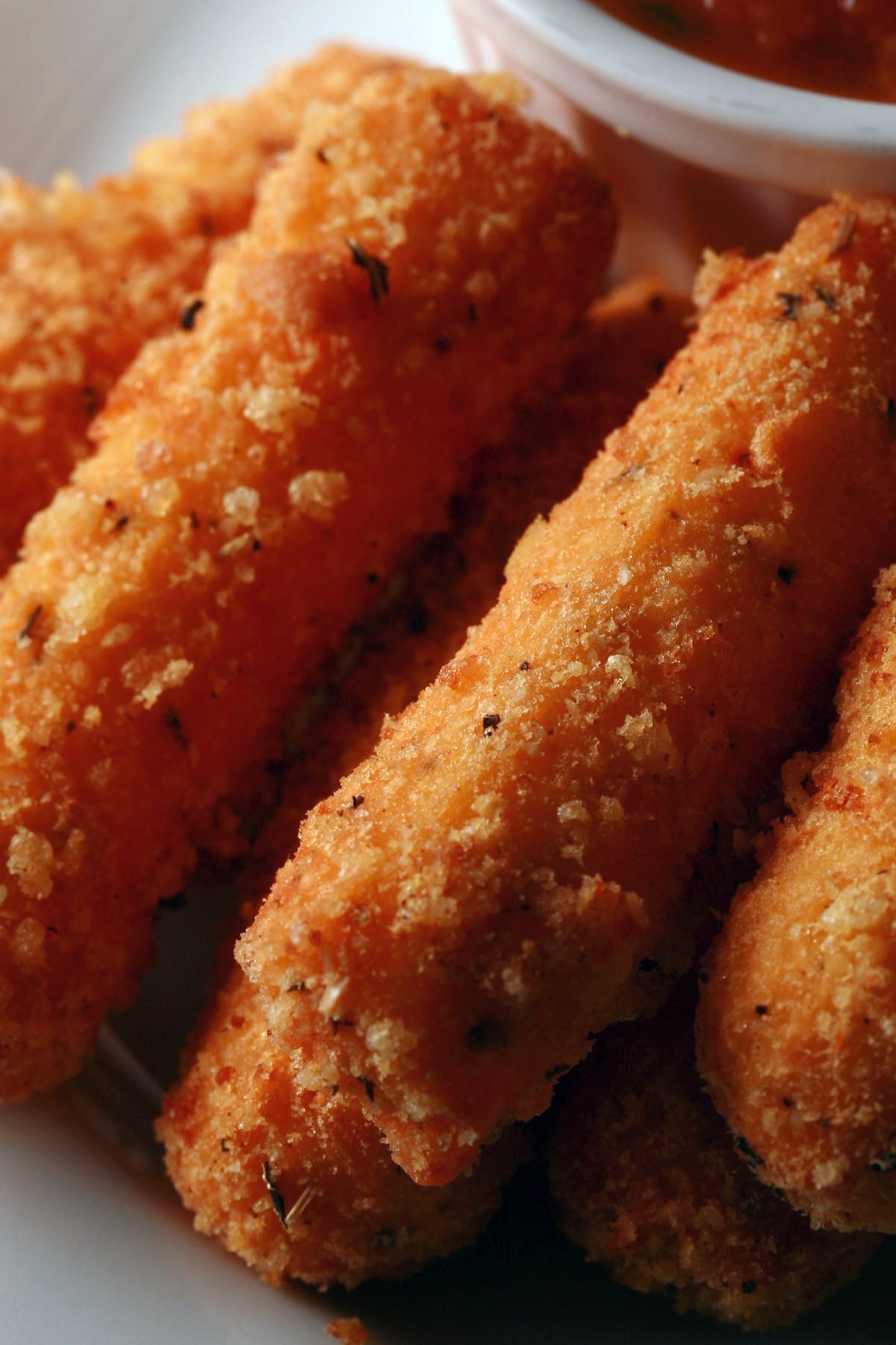 A plate of deep fried low carb mozzarella sticks, with keto marinara sauce.