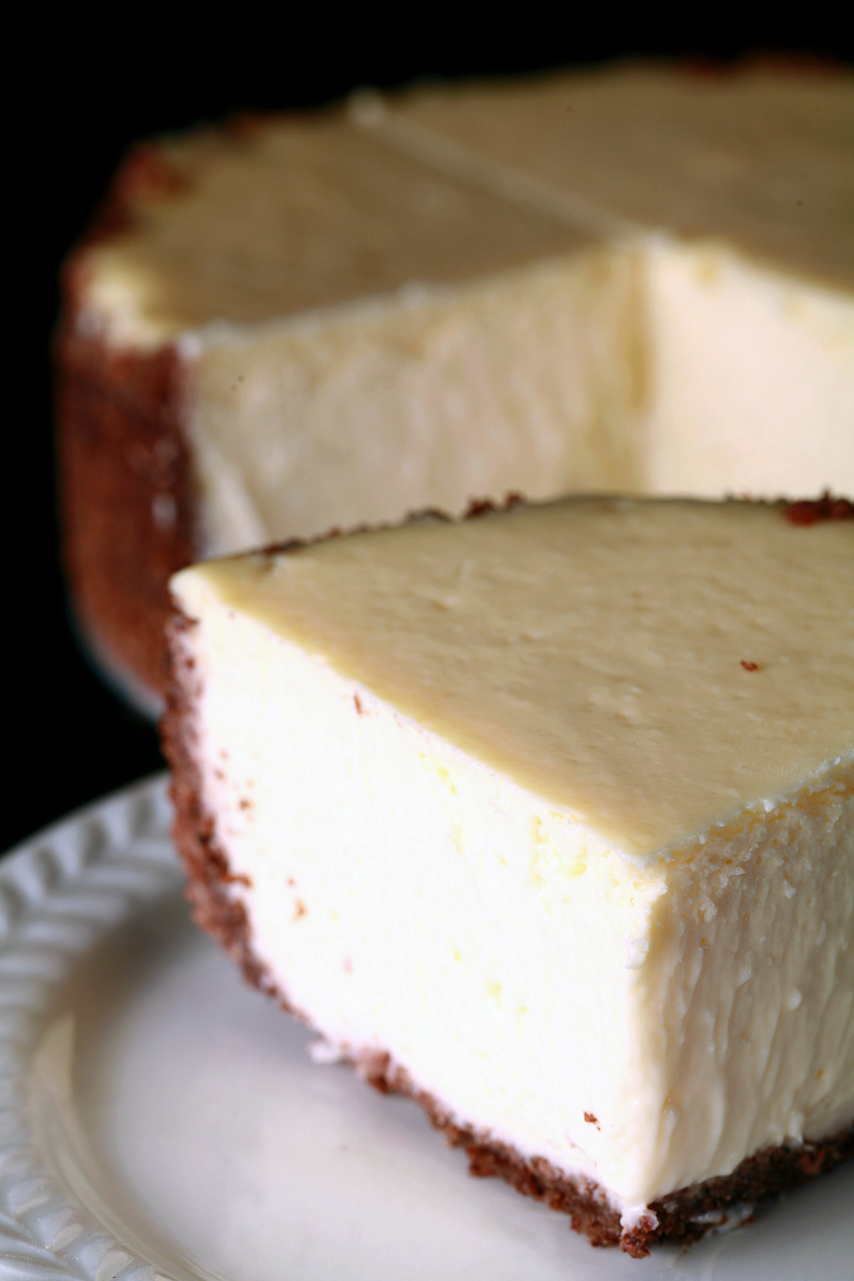 A small 6" low carb cheesecake with a slice cut out of it.