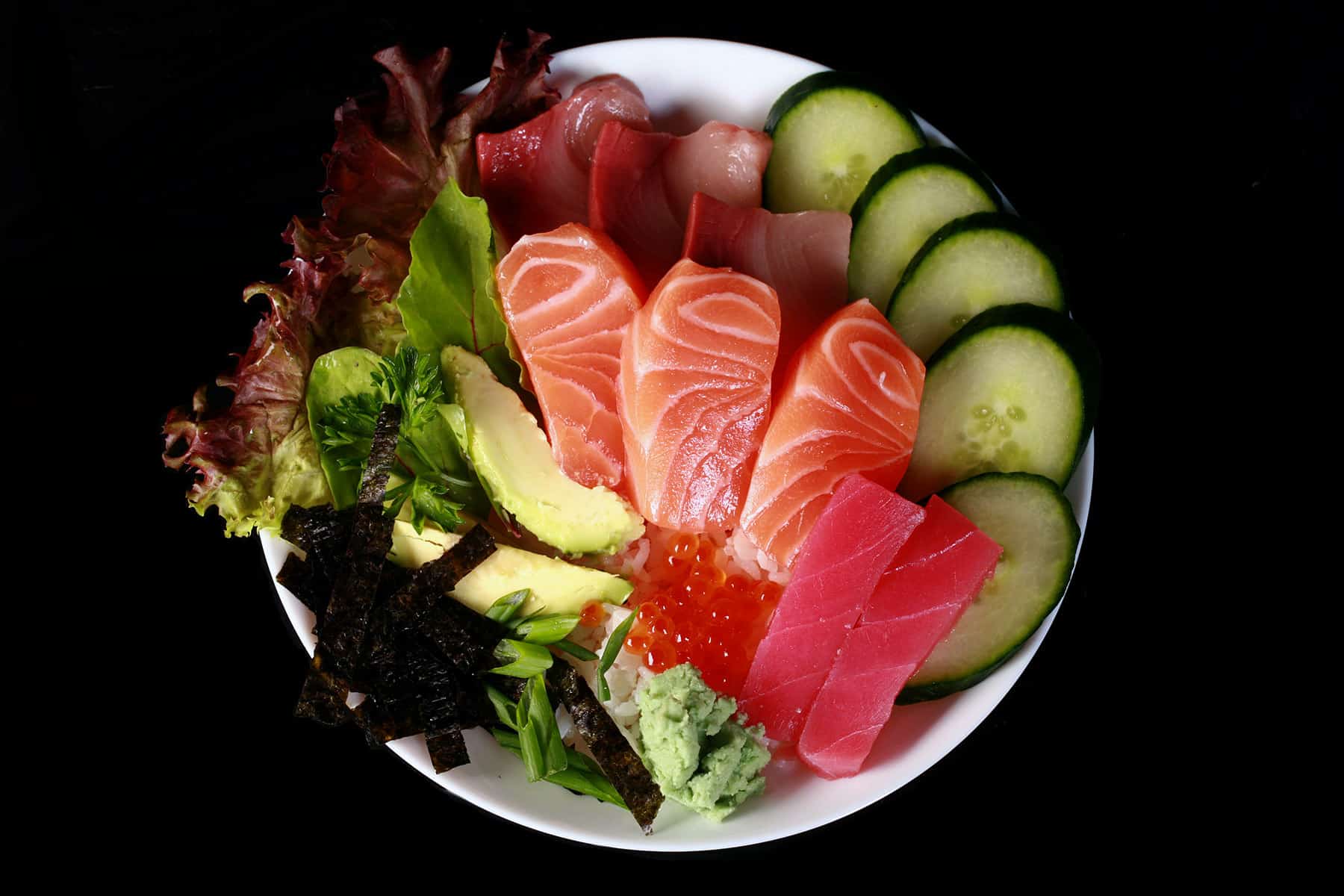 A chirashi bowl - various sashimi and vegetable pieces arranged on a bowl of cauliflower rice.
