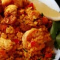 A bowl of low carb paella, with shrimp, chicken, and chorizo visible.