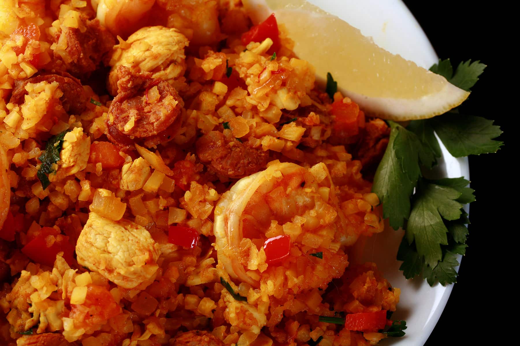 A bowl of low carb paella, with shrimp, chicken, and chorizo visible.
