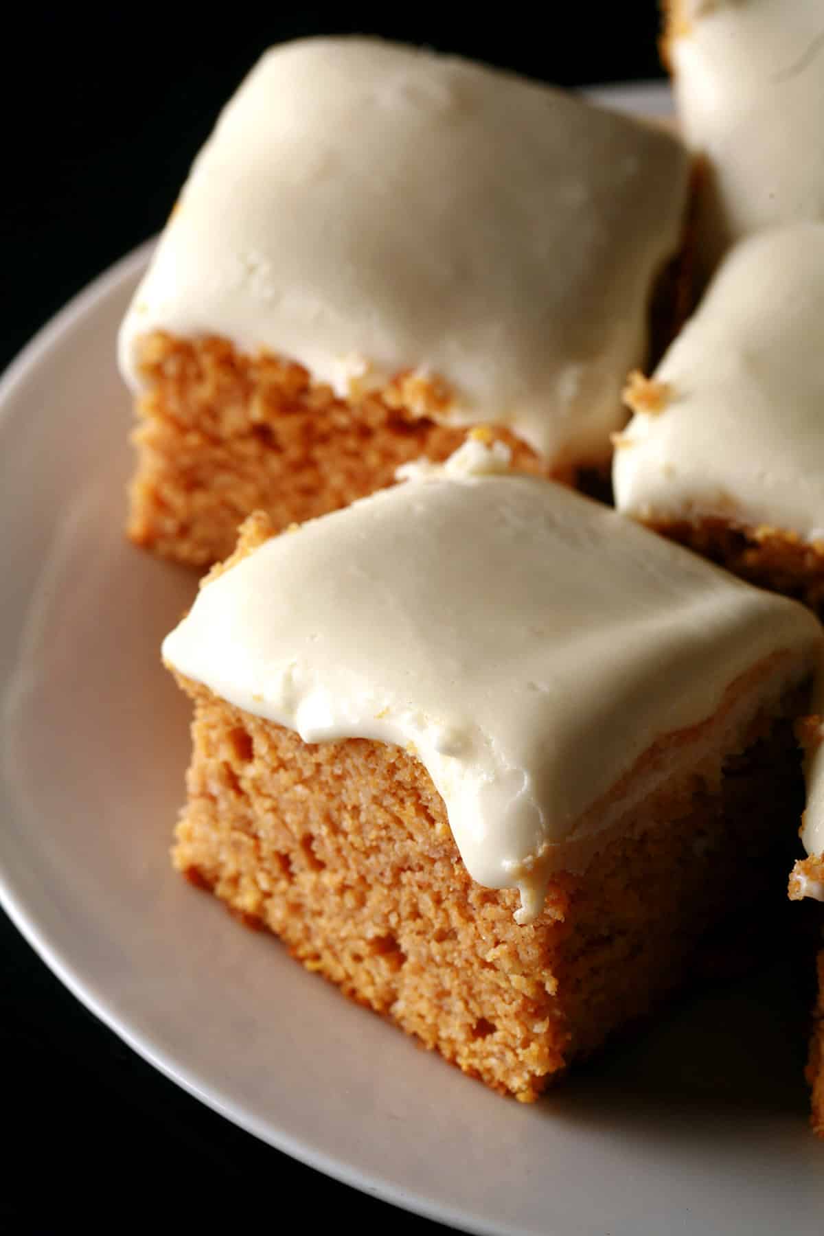 A plate of keto pumpkin bars with cream cheese icing.