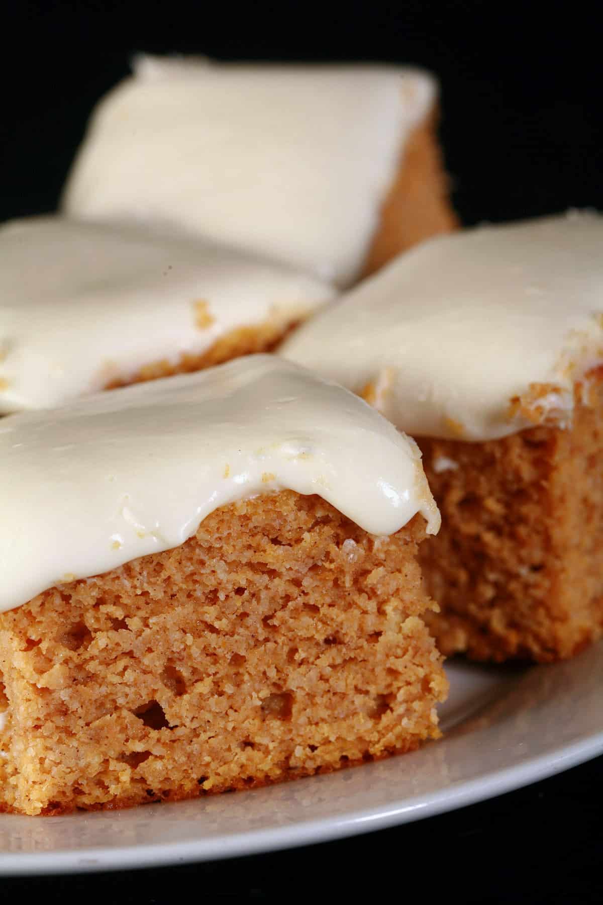 A plate of low carb pumpkin cake bars with cream cheese icing.