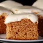 A plate of low carb pumpkin bars with cream cheese frosting.