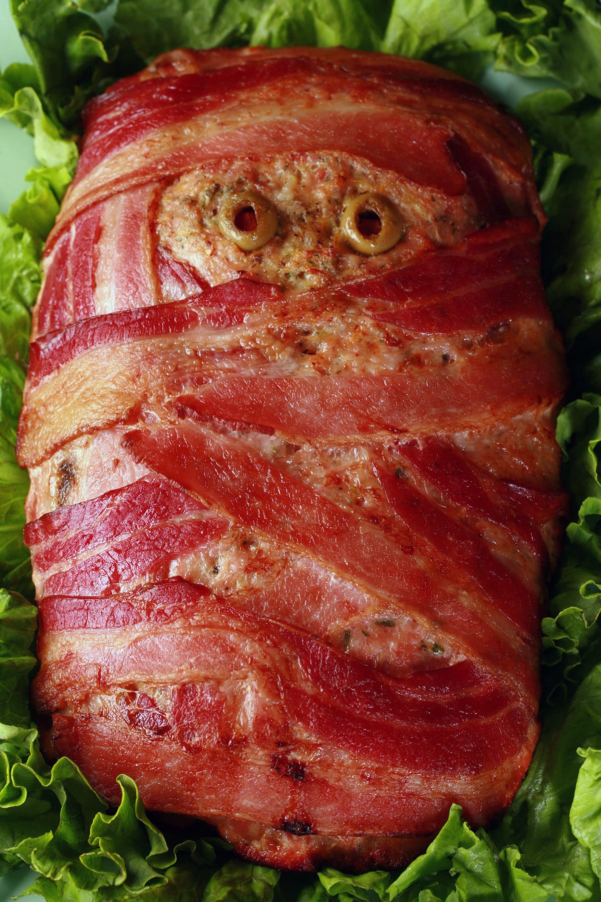 A halloween meatloaf, wrapped in bacon to look like a mummy. It has olive eyes.