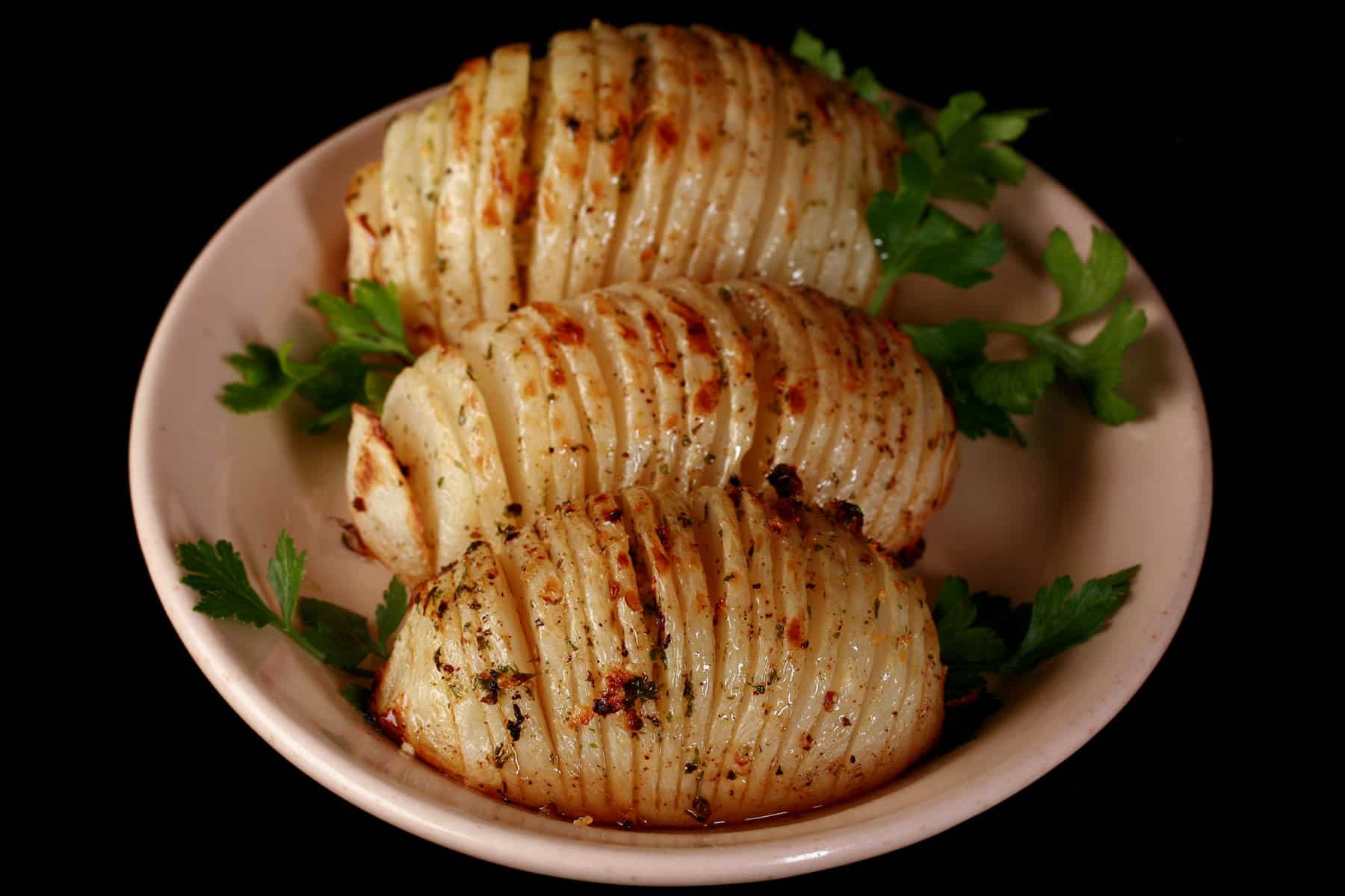 3 hasselback style keto turnips on a plate.