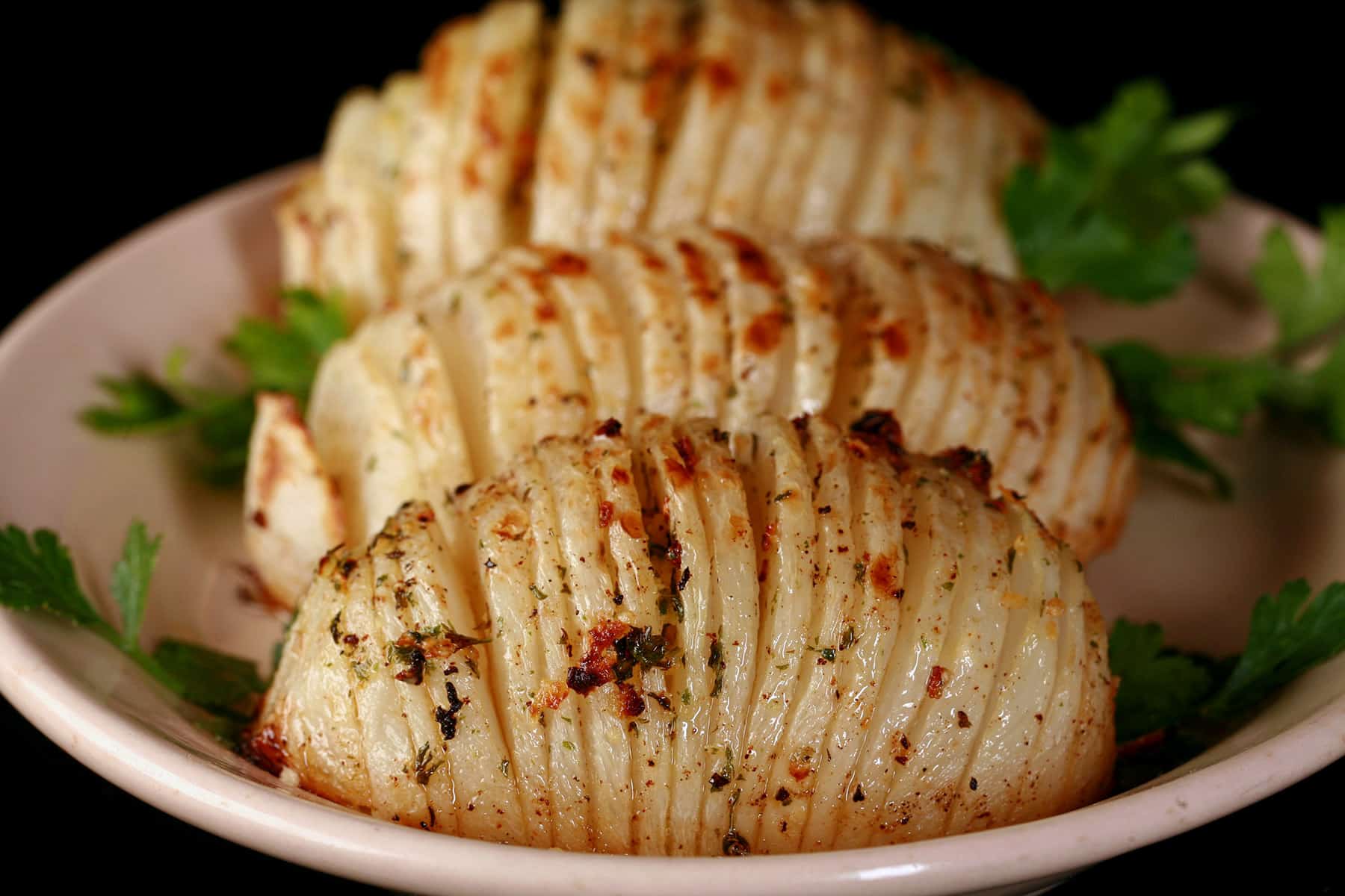 3 hasselback turnips on a plate.