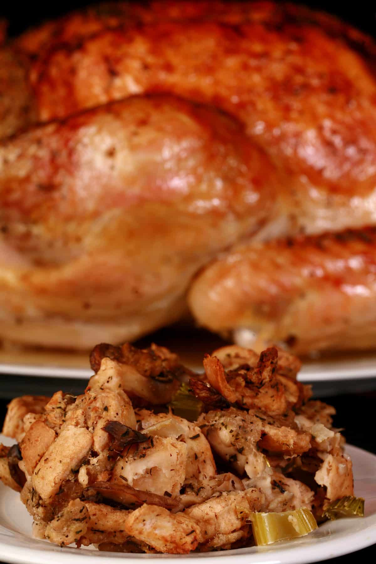 A plate of keto turkey stuffing in front of a roasted turkey.
