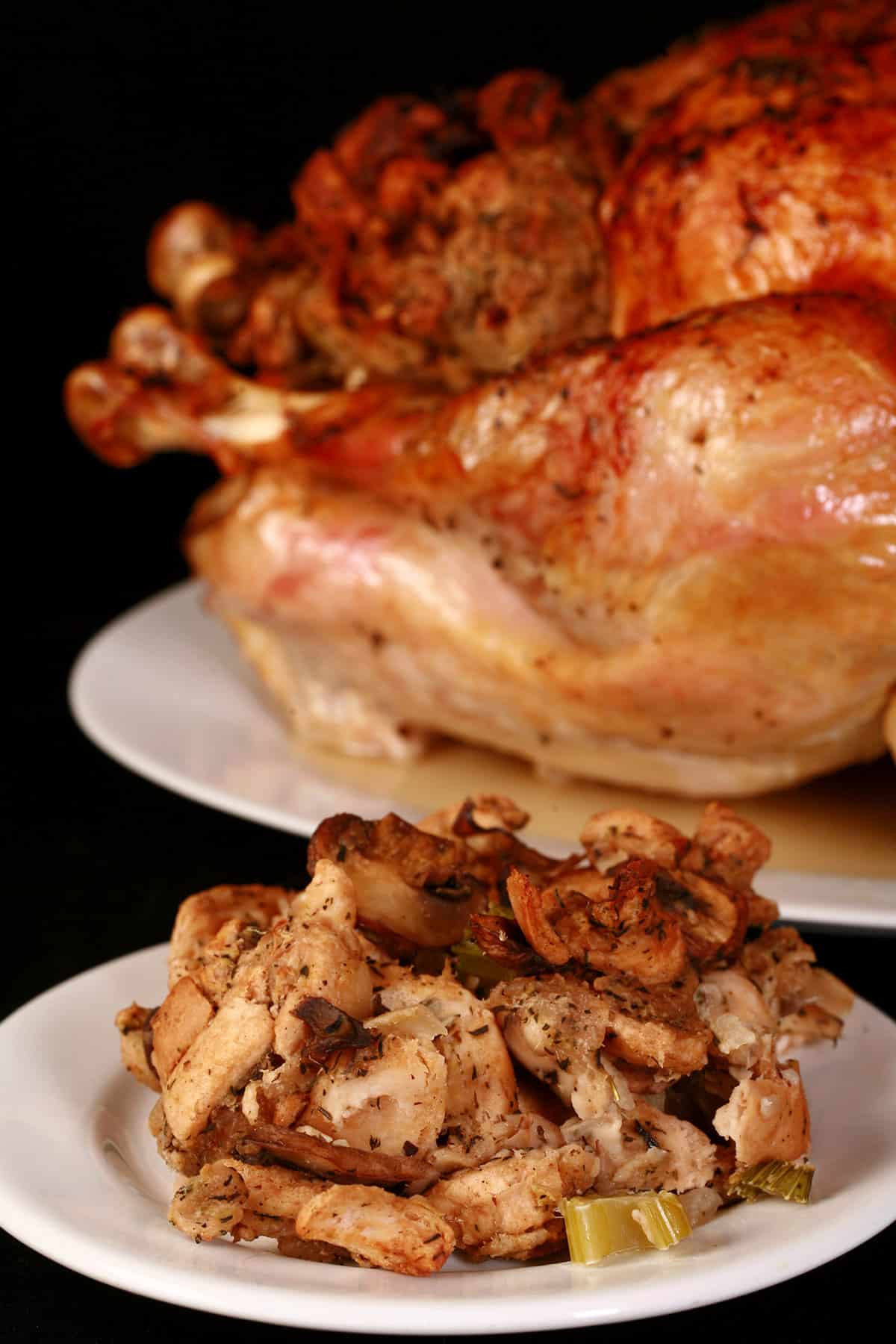 A plate of keto turkey stuffing in front of a roasted turkey.