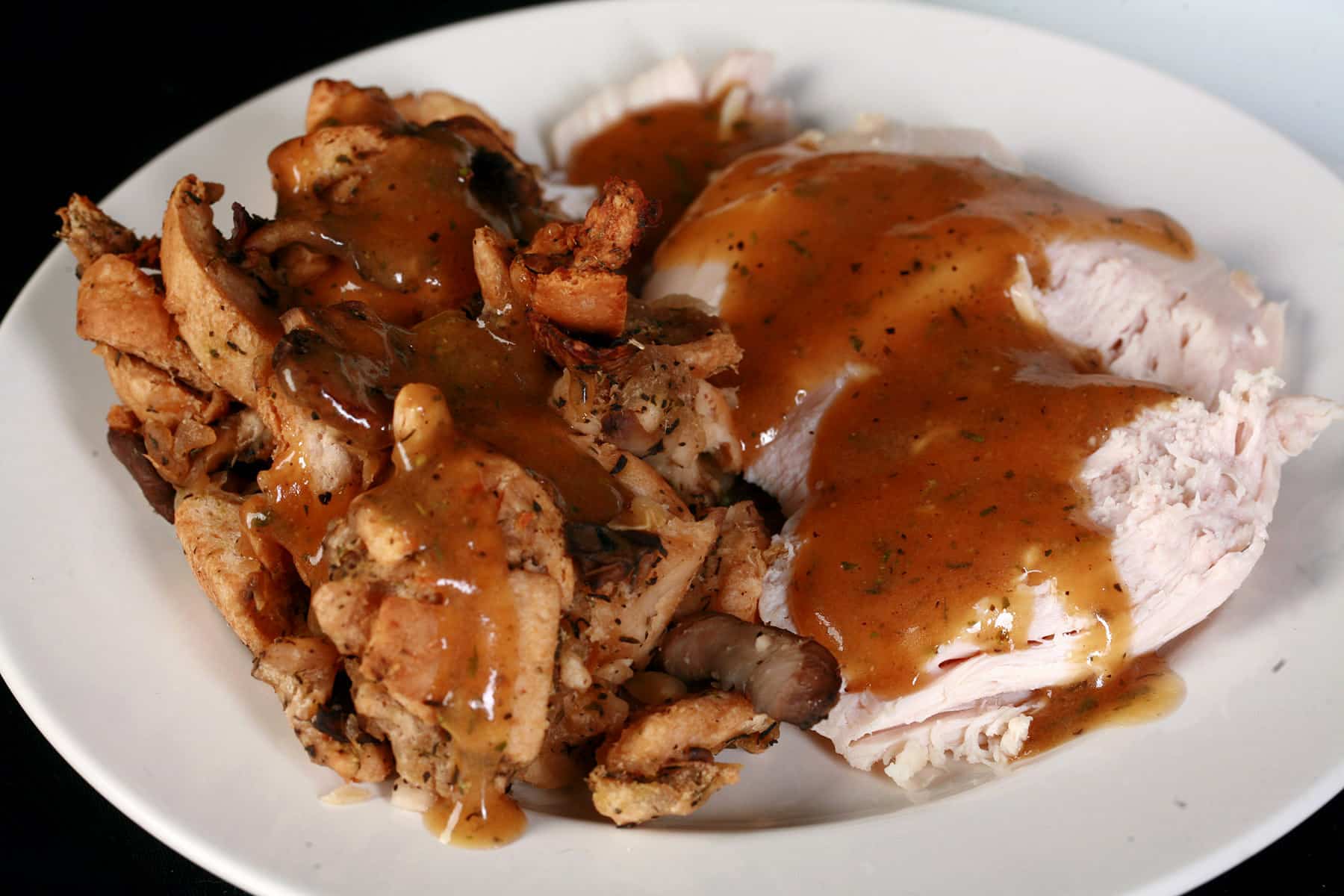 A plate of keto stuffing and turkey, covered in keto turkey gravy.
