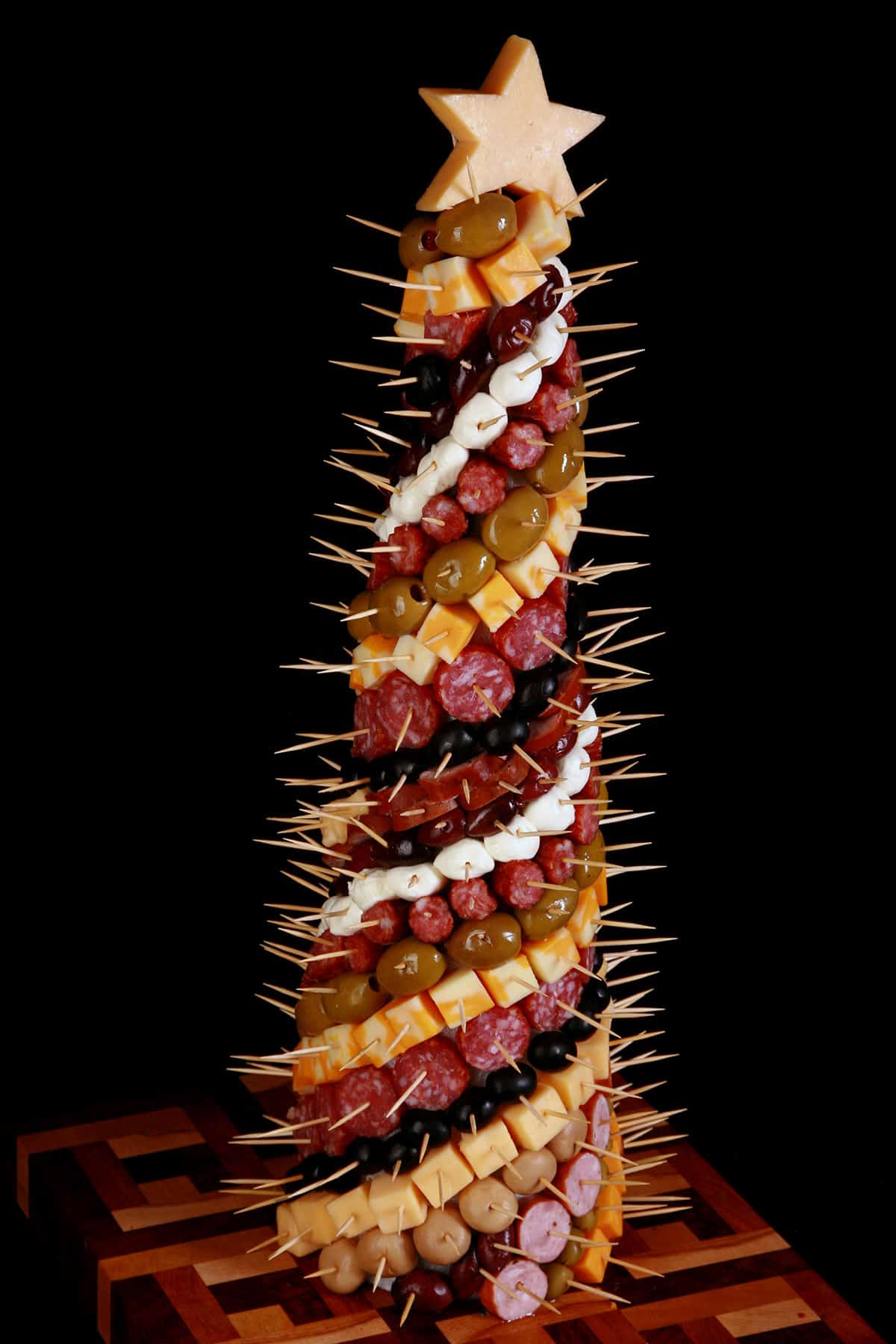 A charcuterie tree, covered in cheese, olives, and cured meats.