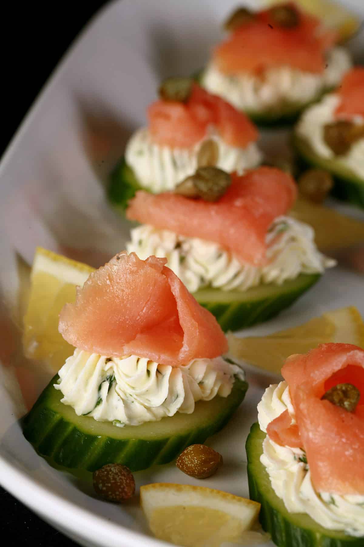 A plate of smoked salmon canapes on cucumber slices.