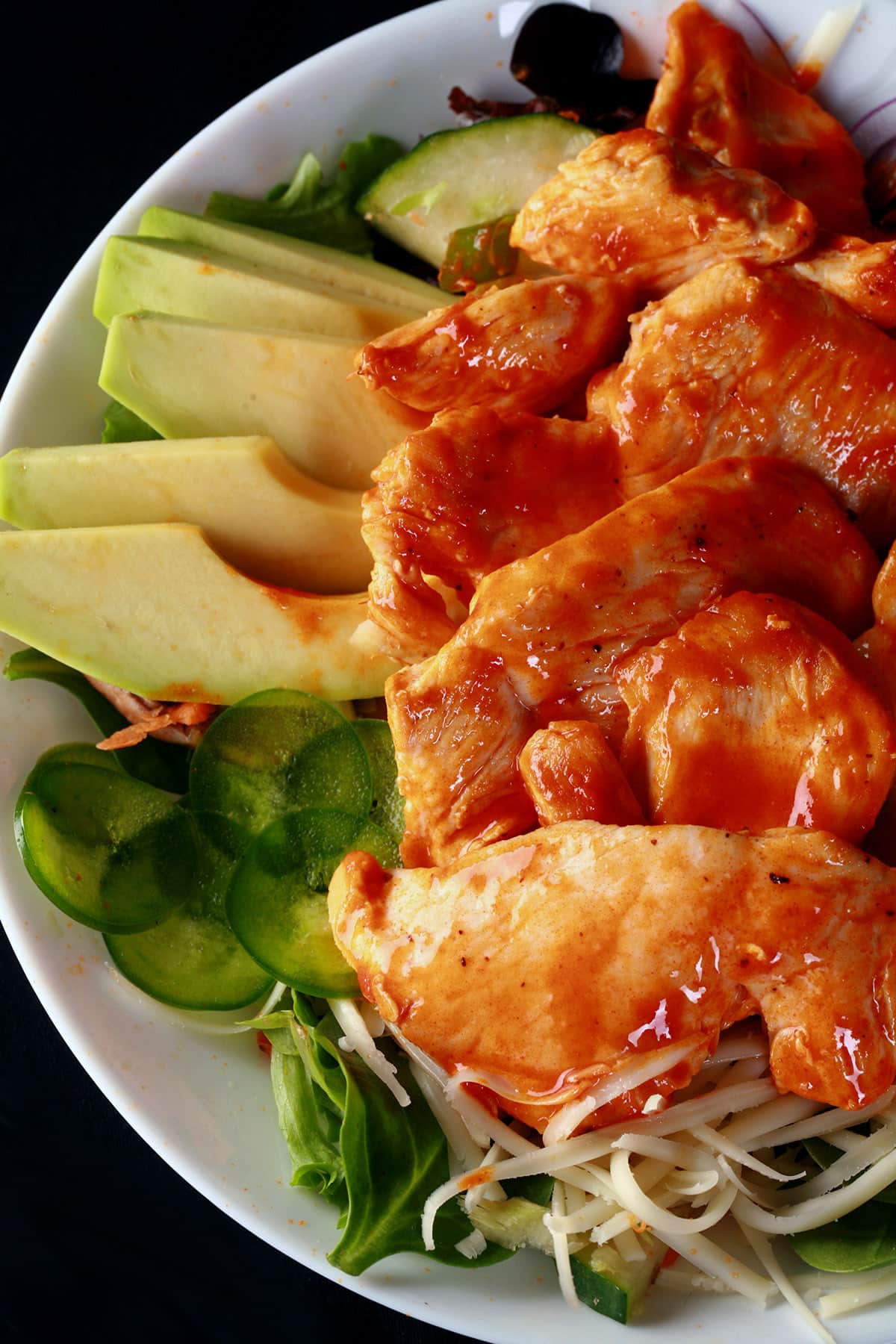 A buffalo chicken salad with buffalo glazed chicken breast on top.