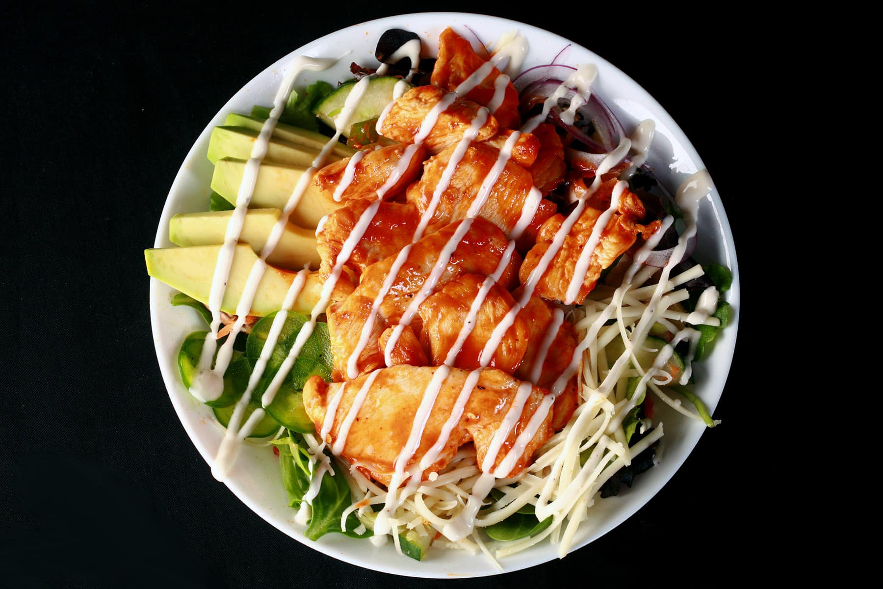 A buffalo chicken salad drizzled with ranch dressing.