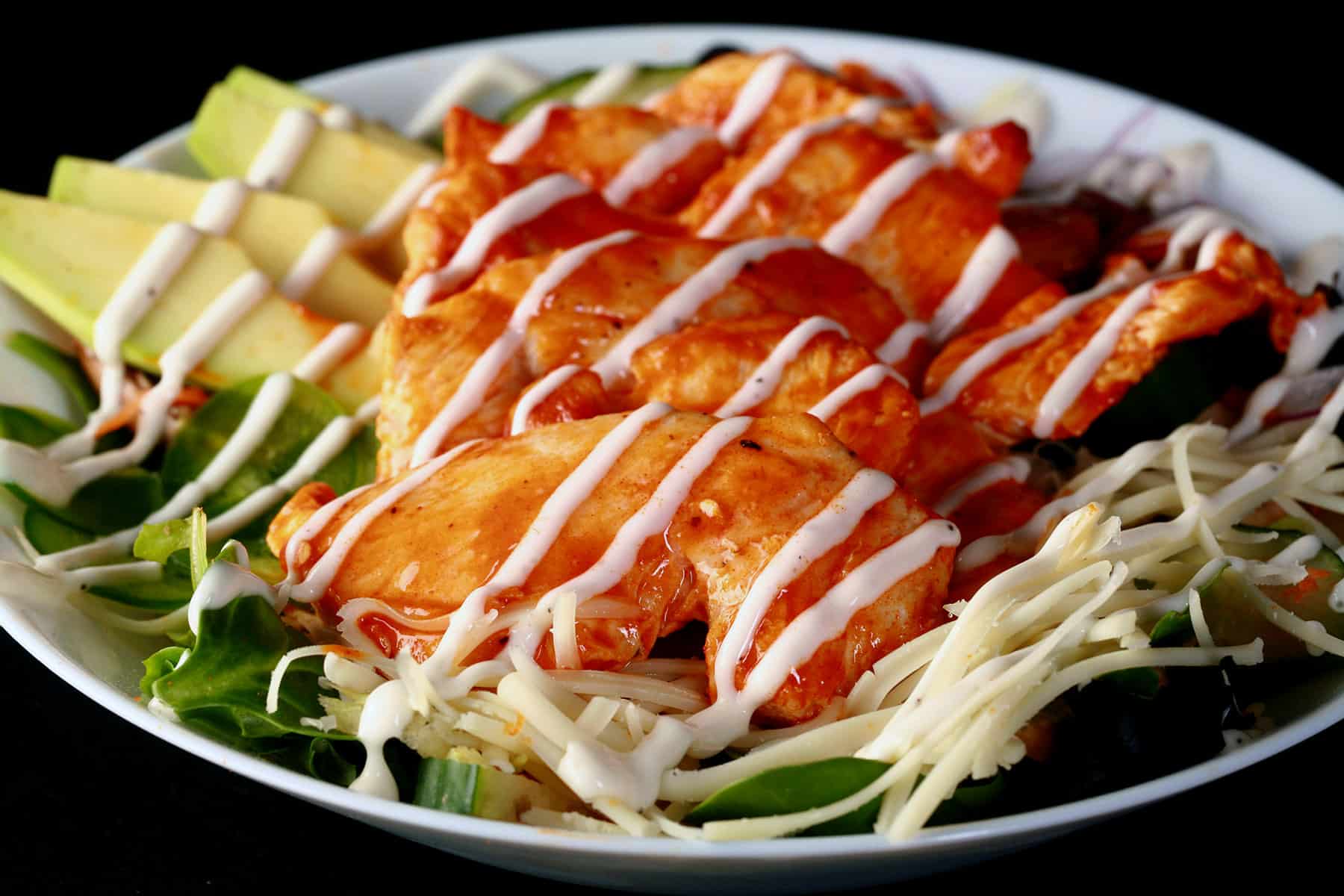 A buffalo chicken salad drizzled with ranch dressing.