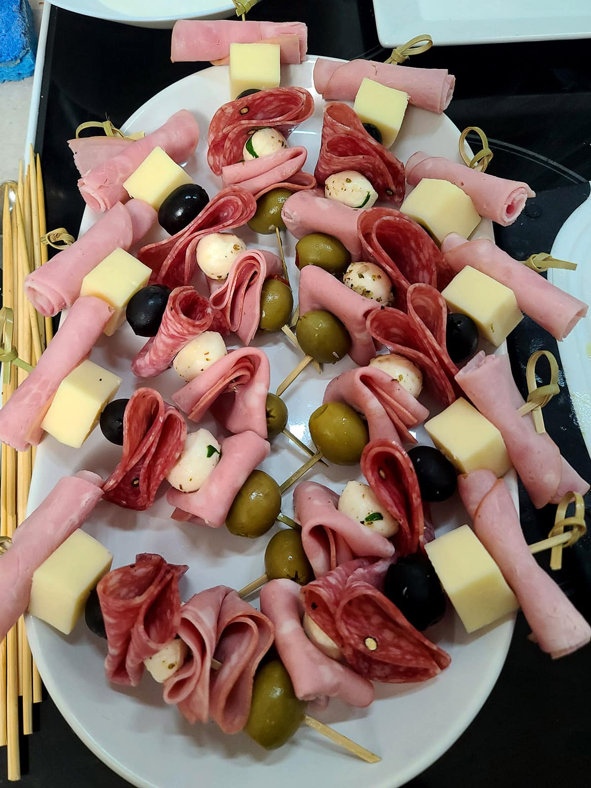 Several finished muffaletta skewered on a cutting board.