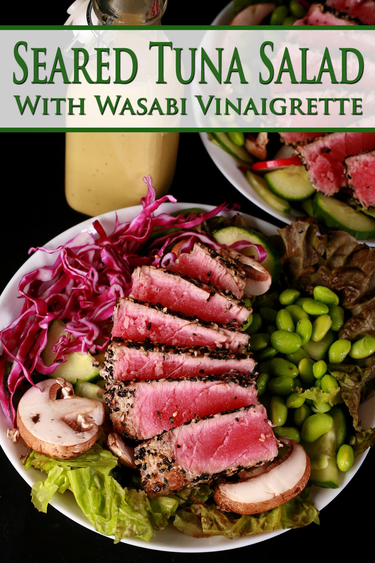 A seared tuna salad with a bottle of creamy wasabi vinaigrette behind it.