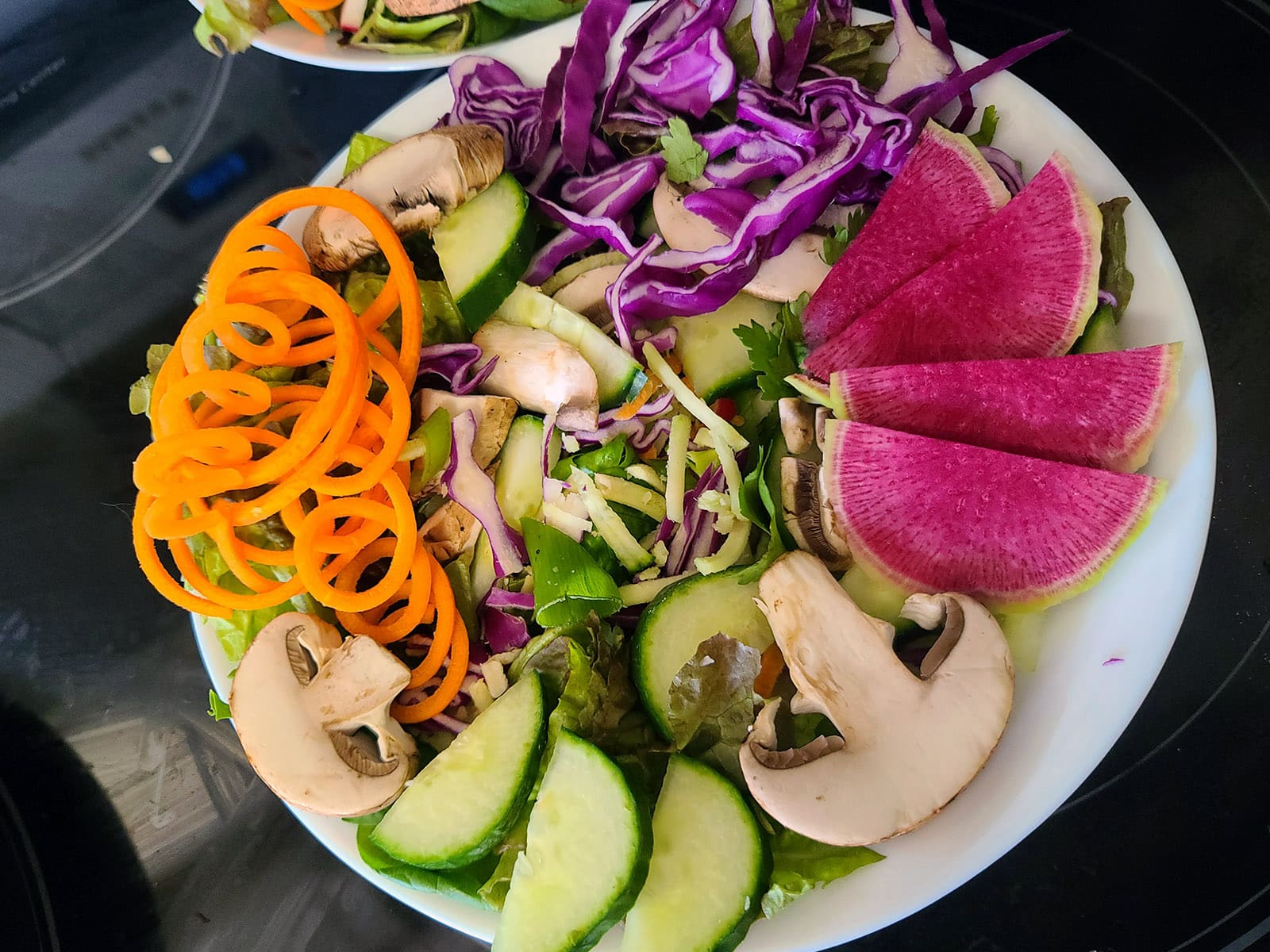 A base salad with the topping ingredients arranged on top.
