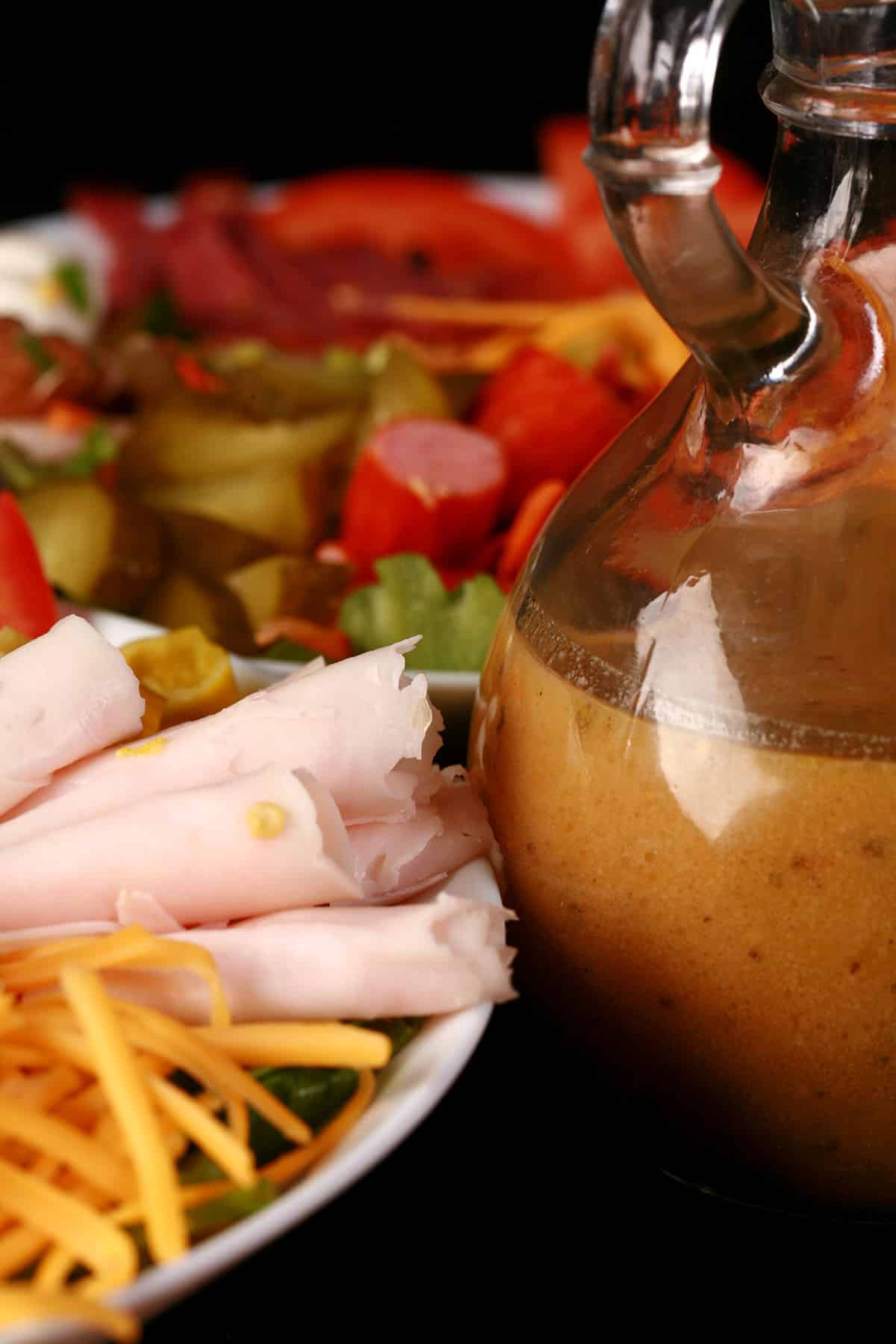 Two Italian Sub Salads with a bottle of dressing.