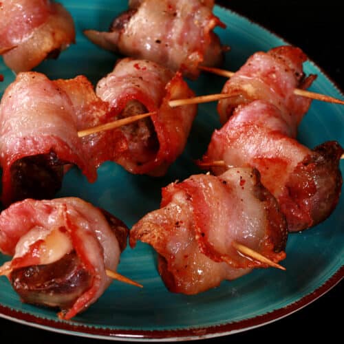 A plate of bacon wrapped chicken livers, each speared with a toothpick.