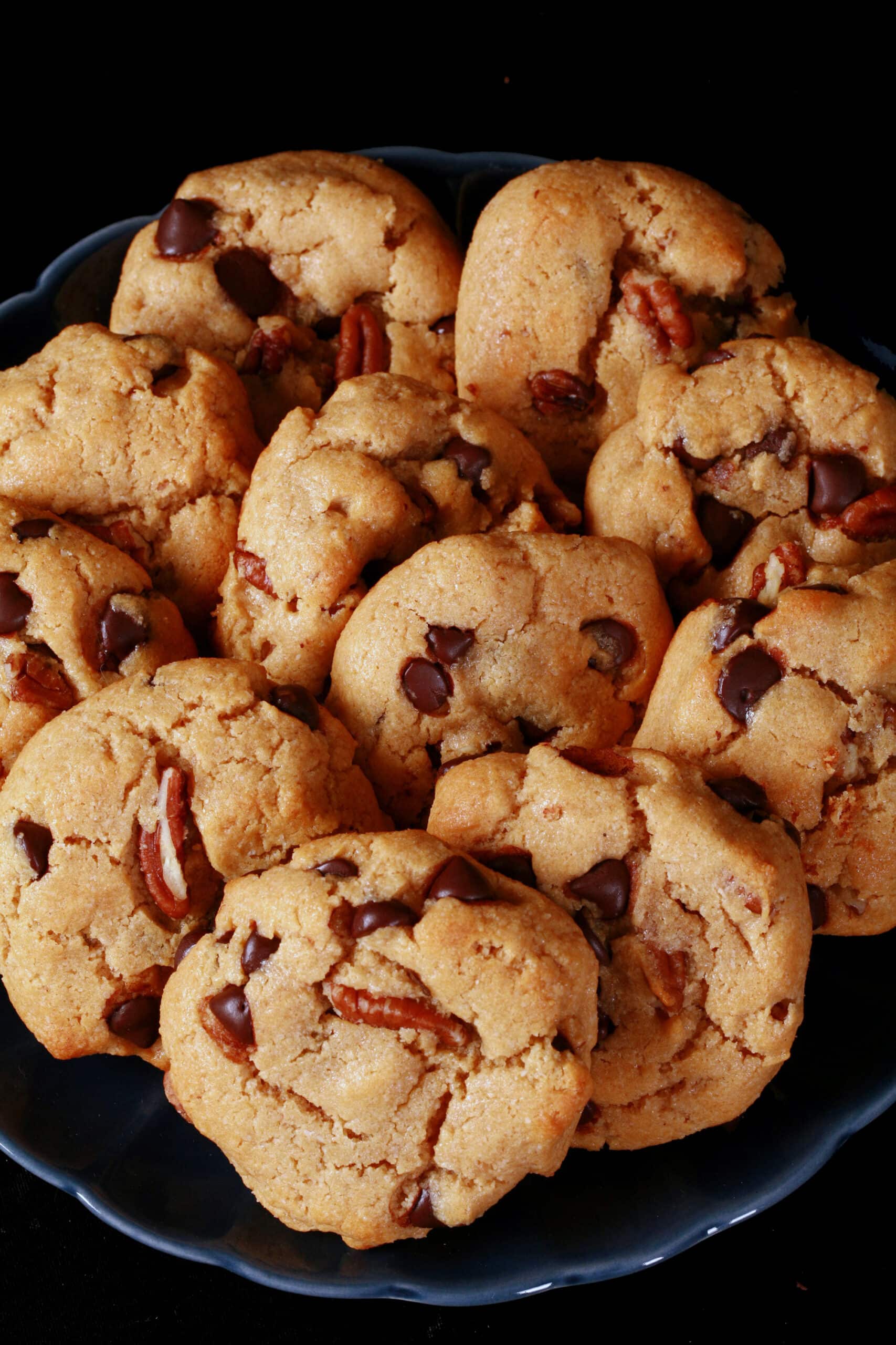 A plate of low carb peanut butter cookies with chocolate chips and pecans.