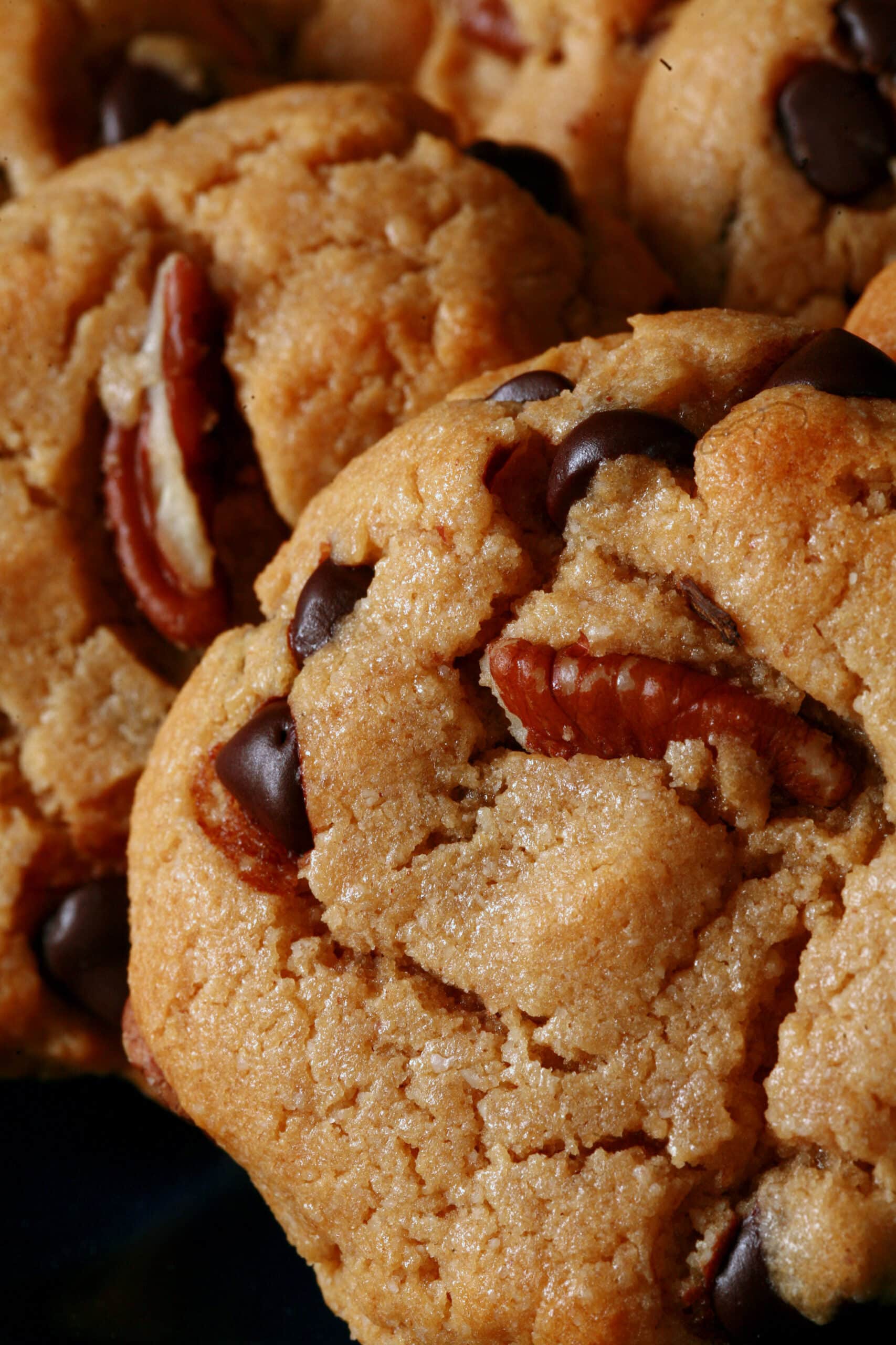 A plate of keto peanut butter cookies with chocolate chips and pecans.