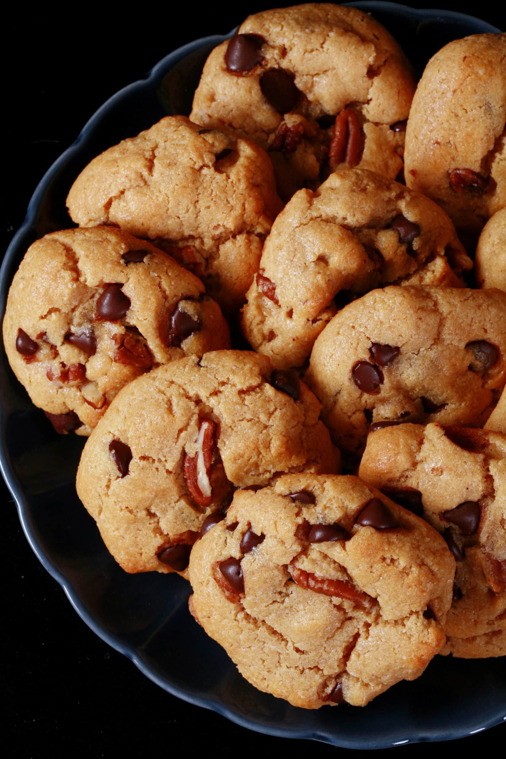 A plate of low carb peanut butter cookies with chocolate chips and pecans.