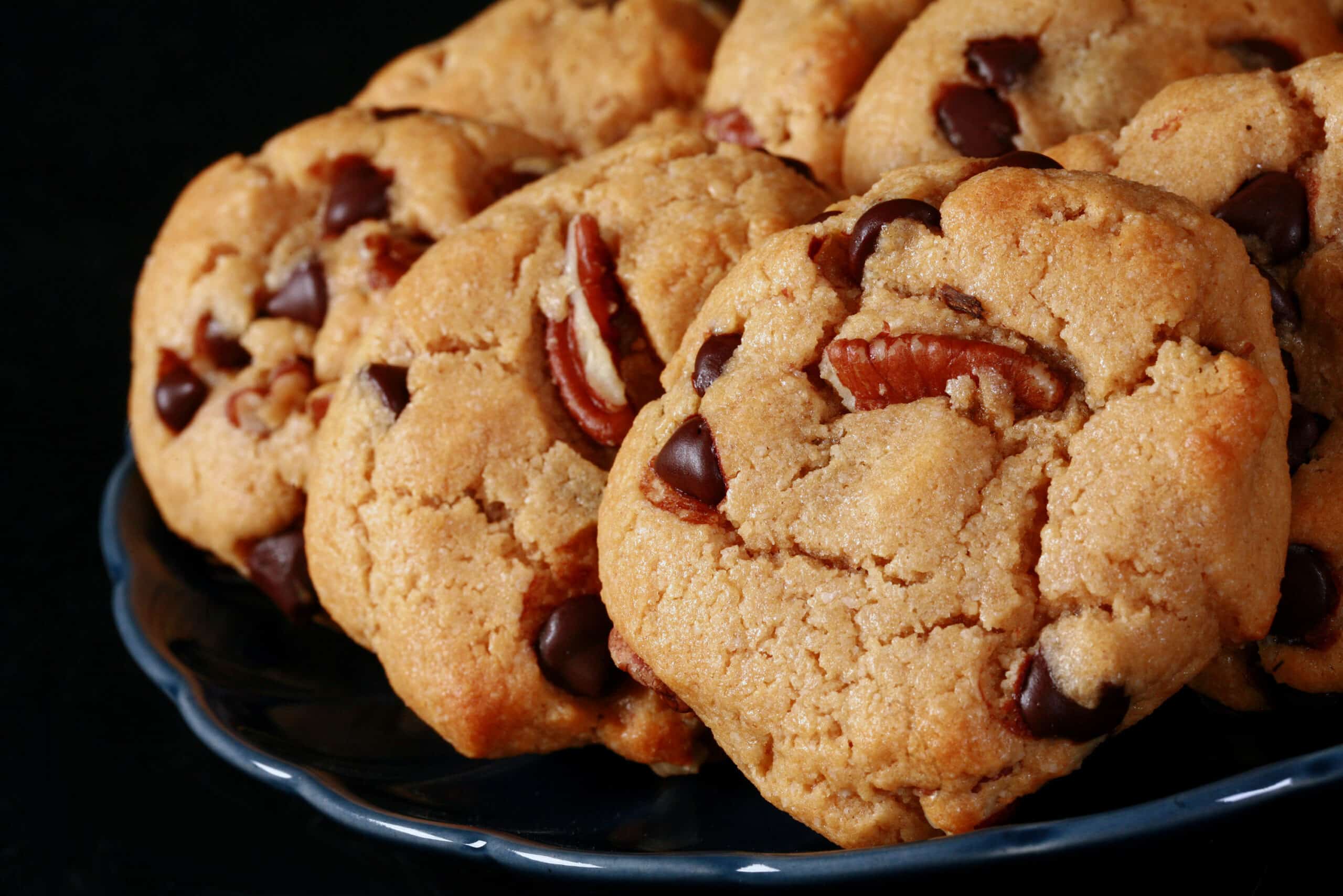 A plate of low carb peanut butter cookies with chocolate chips and pecans.