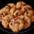 A plate of keto peanut butter cookies with chocolate chips and pecans.