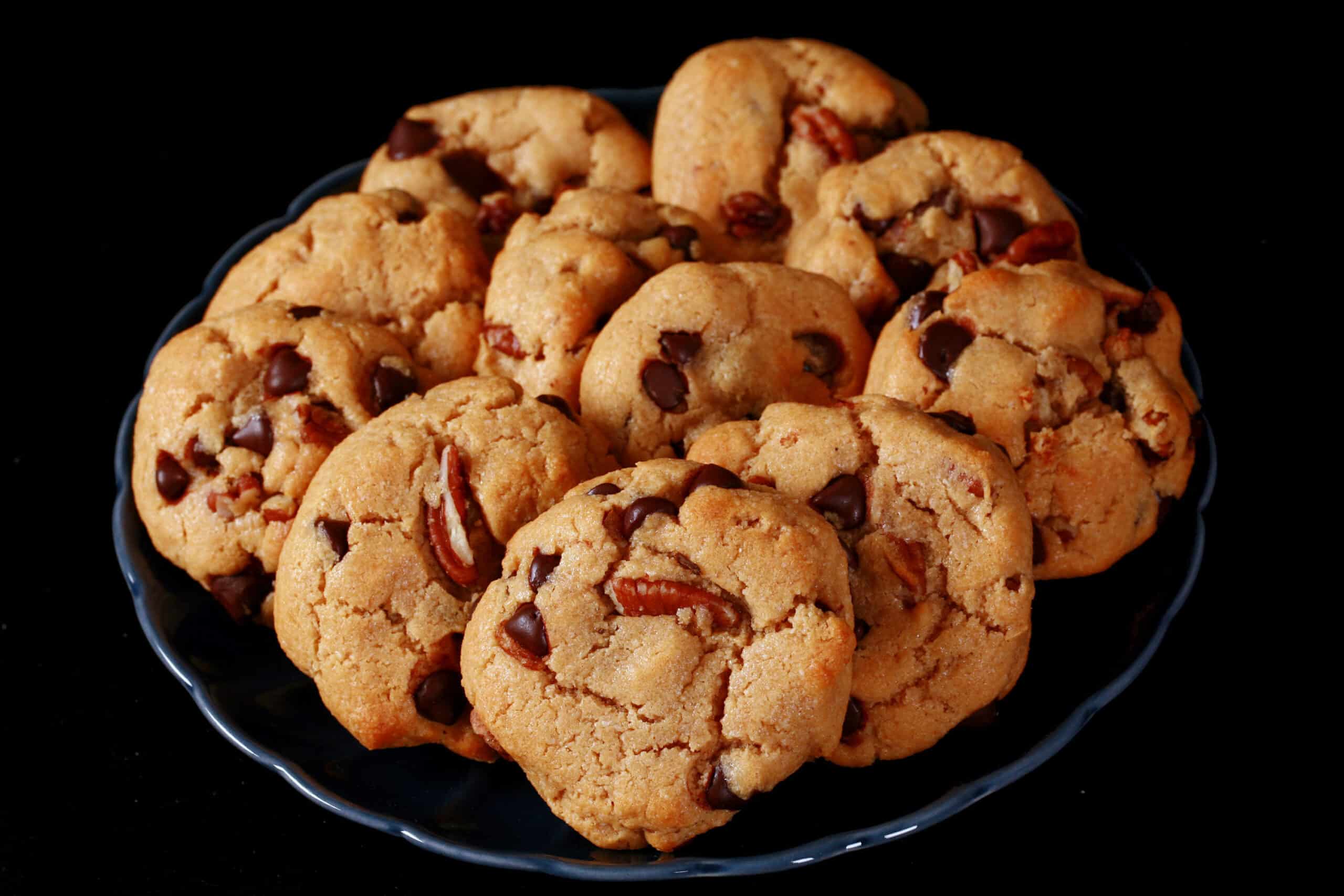 A plate of keto peanut butter cookies with chocolate chips and pecans.