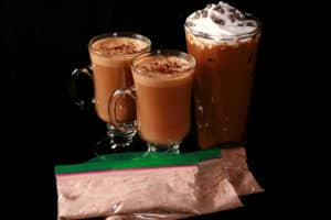 2 keto mocha lattes and a protein powder iced mocha latte topped with whipped cream and sugar free mini chocolate chips. There are several bags of mix with the drinks.