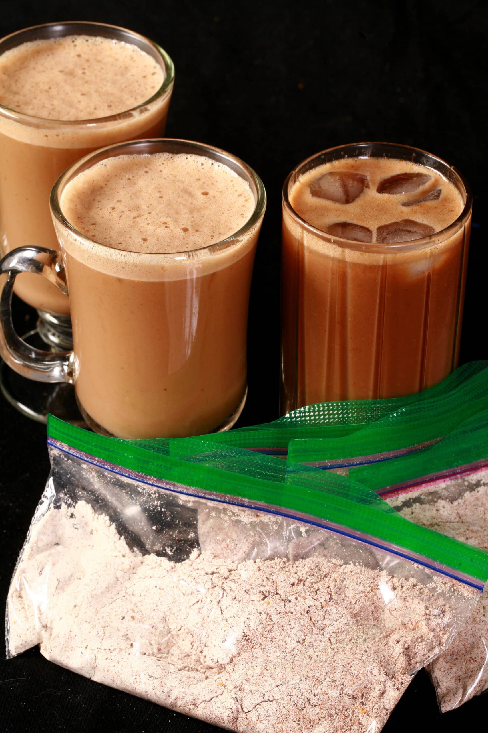 A protein powder iced pumpkin spice latte, 2 keto pumpkin spice lattes, and several bags of mix to make them.