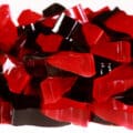 A pile of 2 colored red and brown coke bottle shaped keto sour cherry cola gummies.